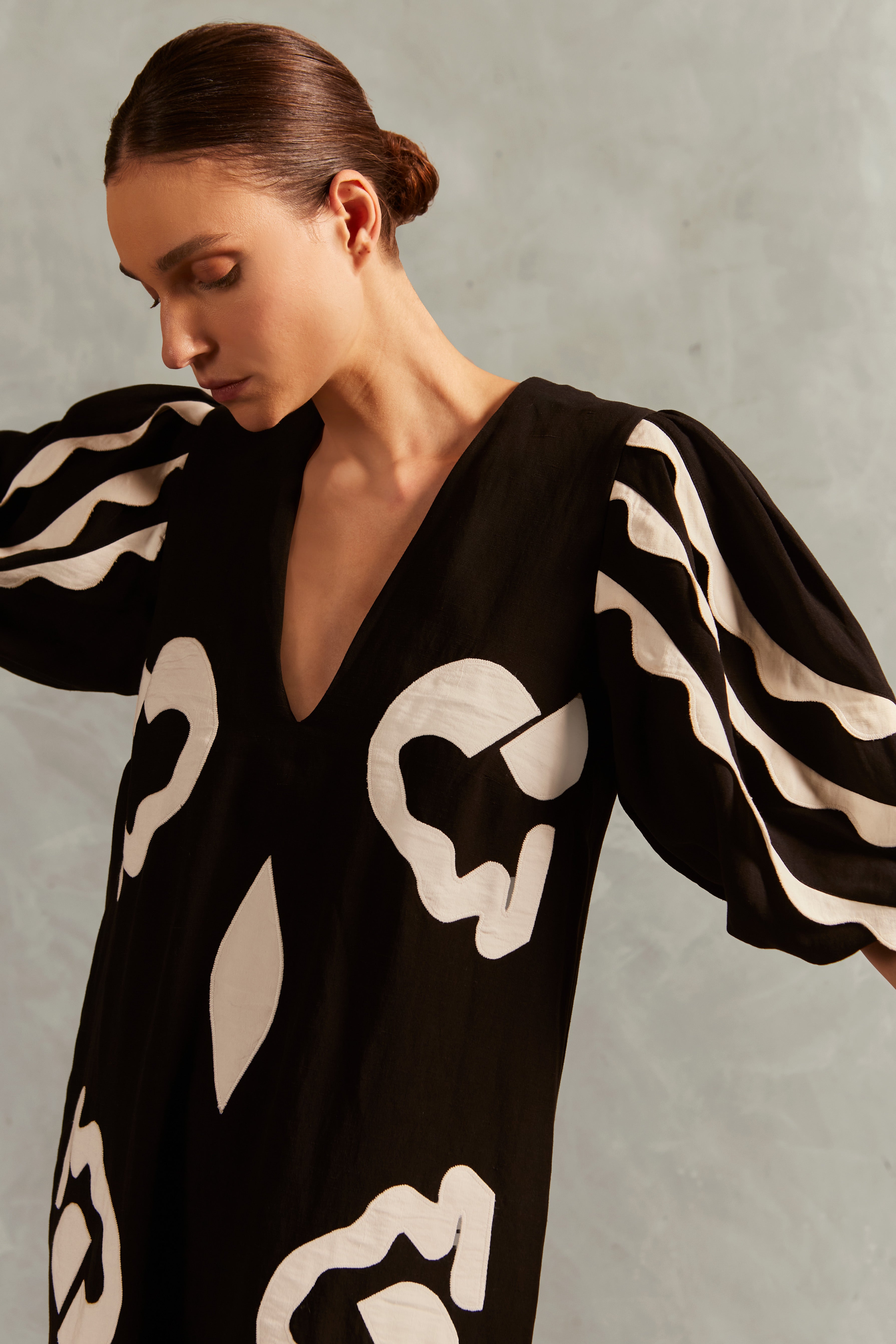 Model wearing the Appliqué V-Neck Long Dress Detail showcasing its Black print on 55% Linen 45% Viscose fabric, styled for an afternoon look.