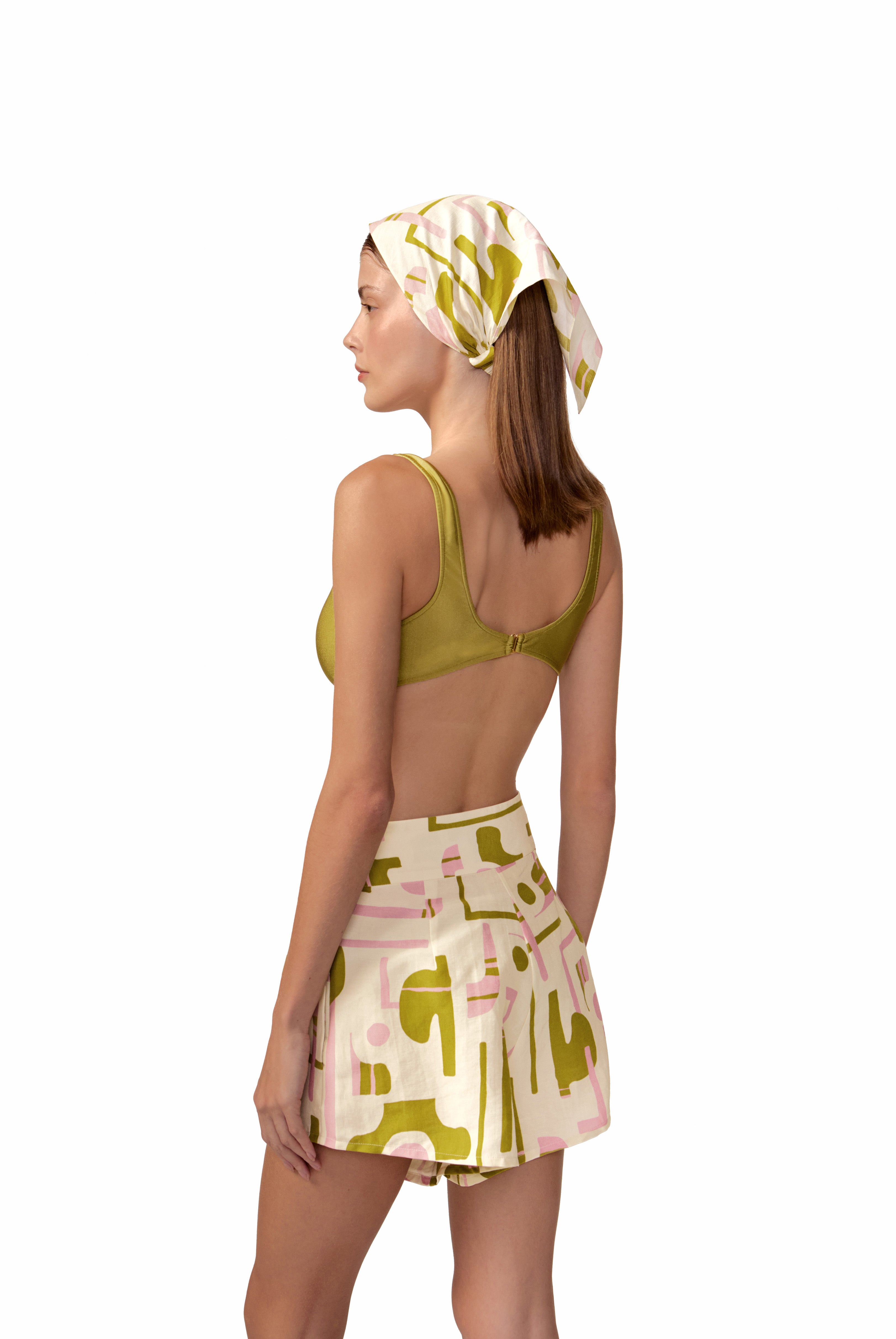 Model wearing the Balearic Pleated Shorts back color navy made with 56% viscose 44% Linen, styled for resortwear look