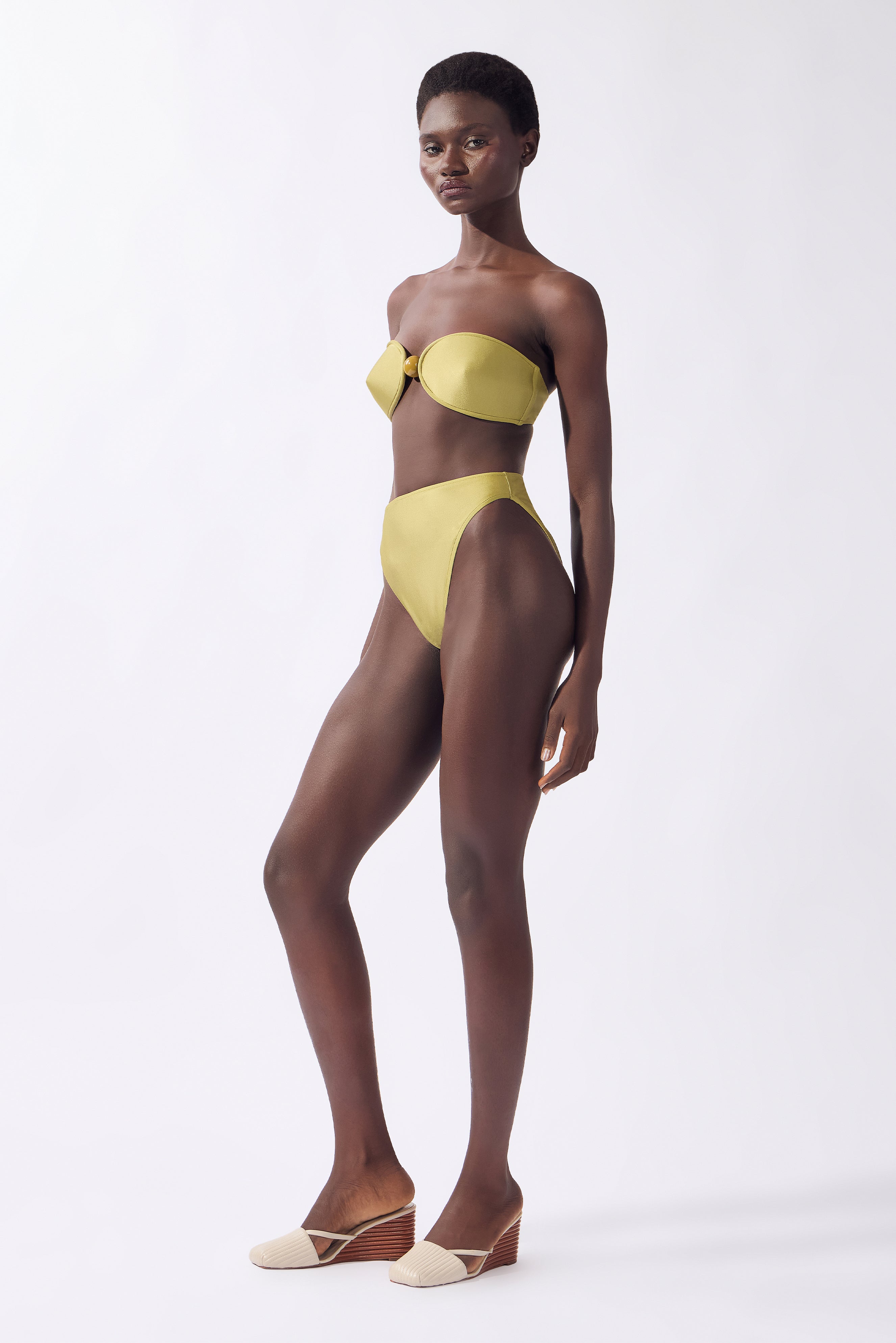 Model wearing the Bandeau High-Leg Bikini Set look color unique, made from 85% polyamide 15% elastane, styled for beachwear look