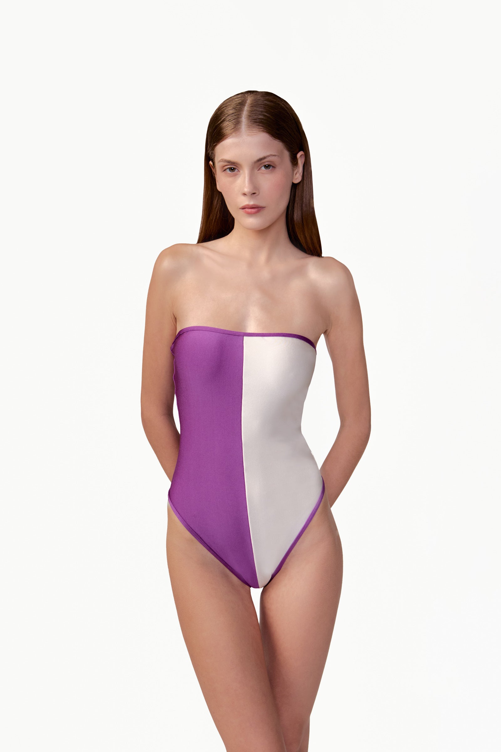 Model wearing the Bicolor High-Leg Swimsuit detail color purple, made from 85% plyamide 15% elastane, styled for a beachwear look