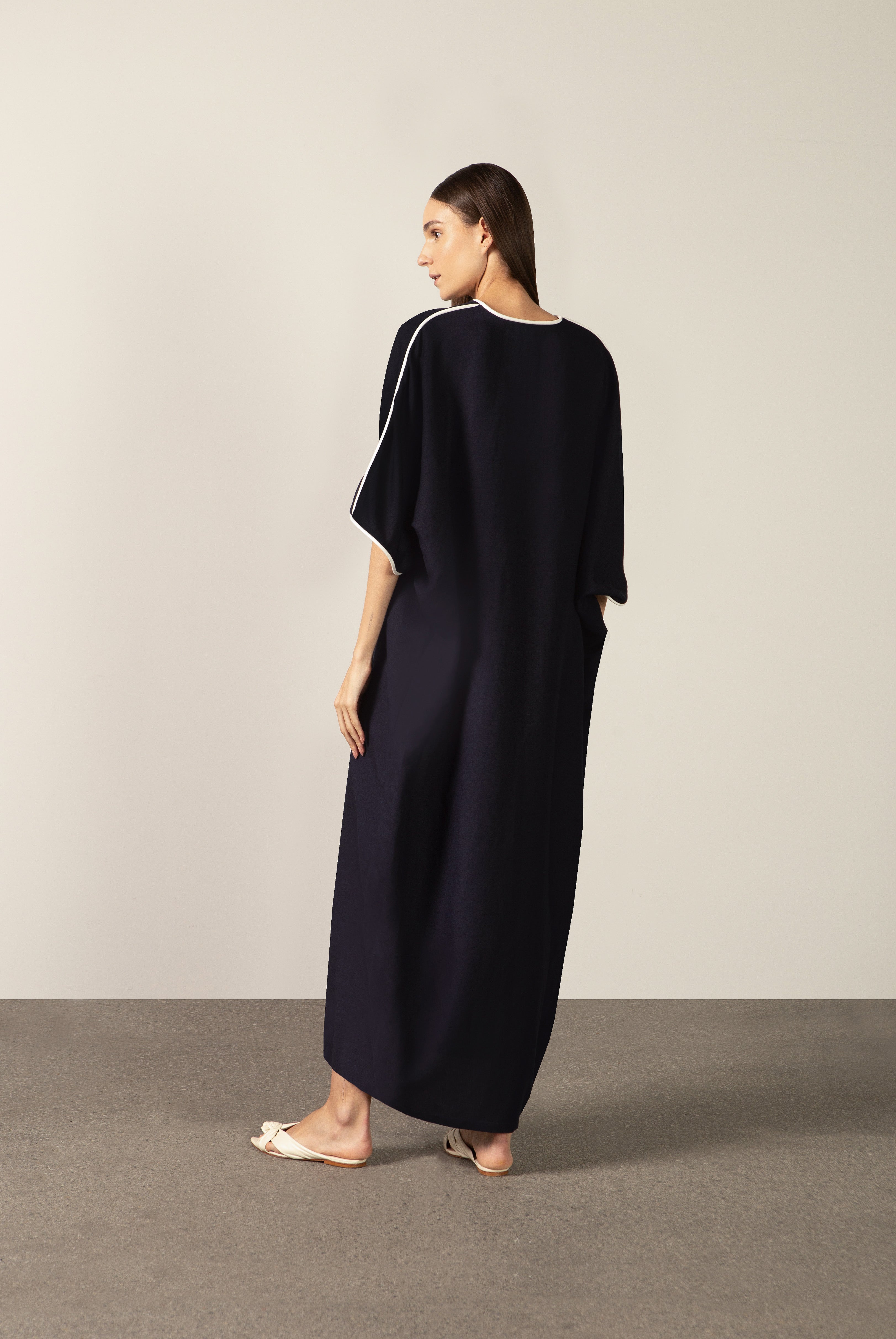 Model wearing the Bicolor Maxi Kaftan back color navy made with 56% viscose 44% Linen, styled for resortwear look