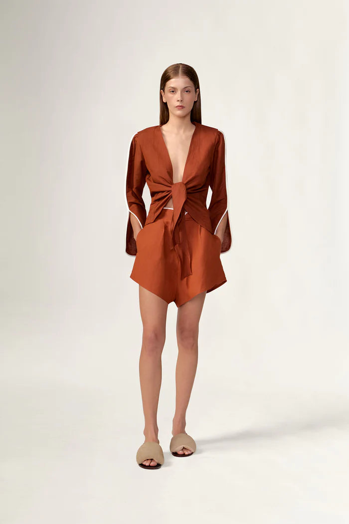 Model wearing the Bicolor Shorts front color cognac made with 55% viscose 45% Linen, styled for resortwear look