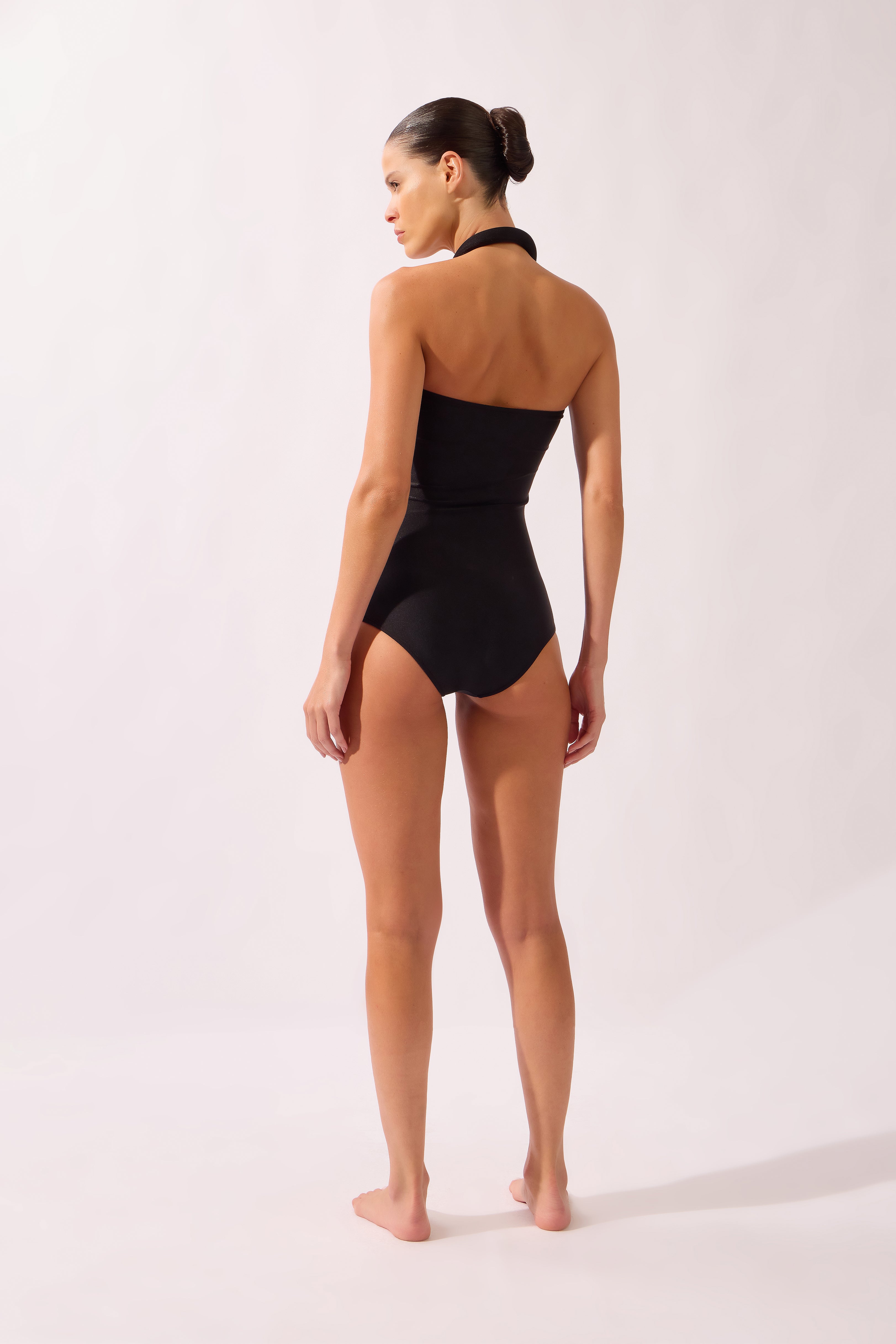 Model wearing the Bold Noir Swimsuit back color black, made from 85% polyamide 15% elastane, styled for a beachwear look