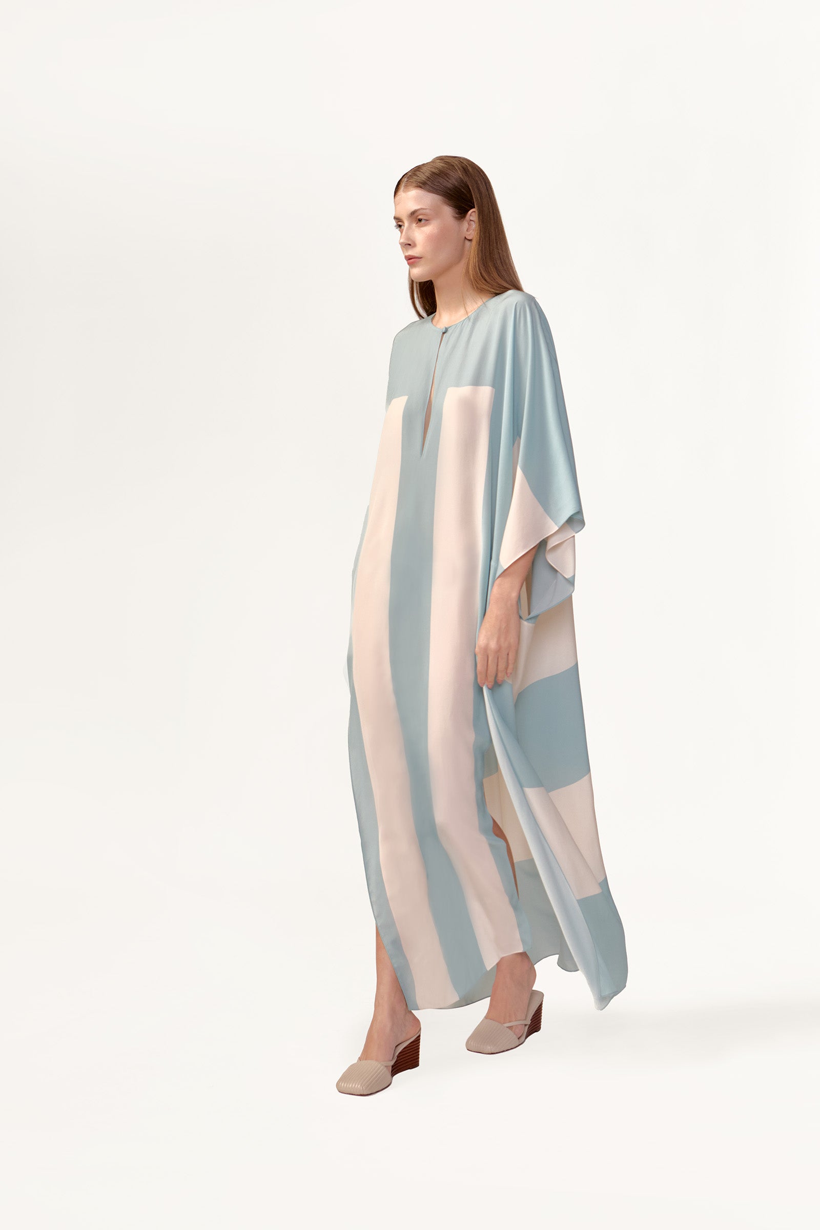 Model wearing the Bold Stripes Maxi Kaftan look showcasing its blue print on 100% Viscose fabric, styled for an post-beach look.