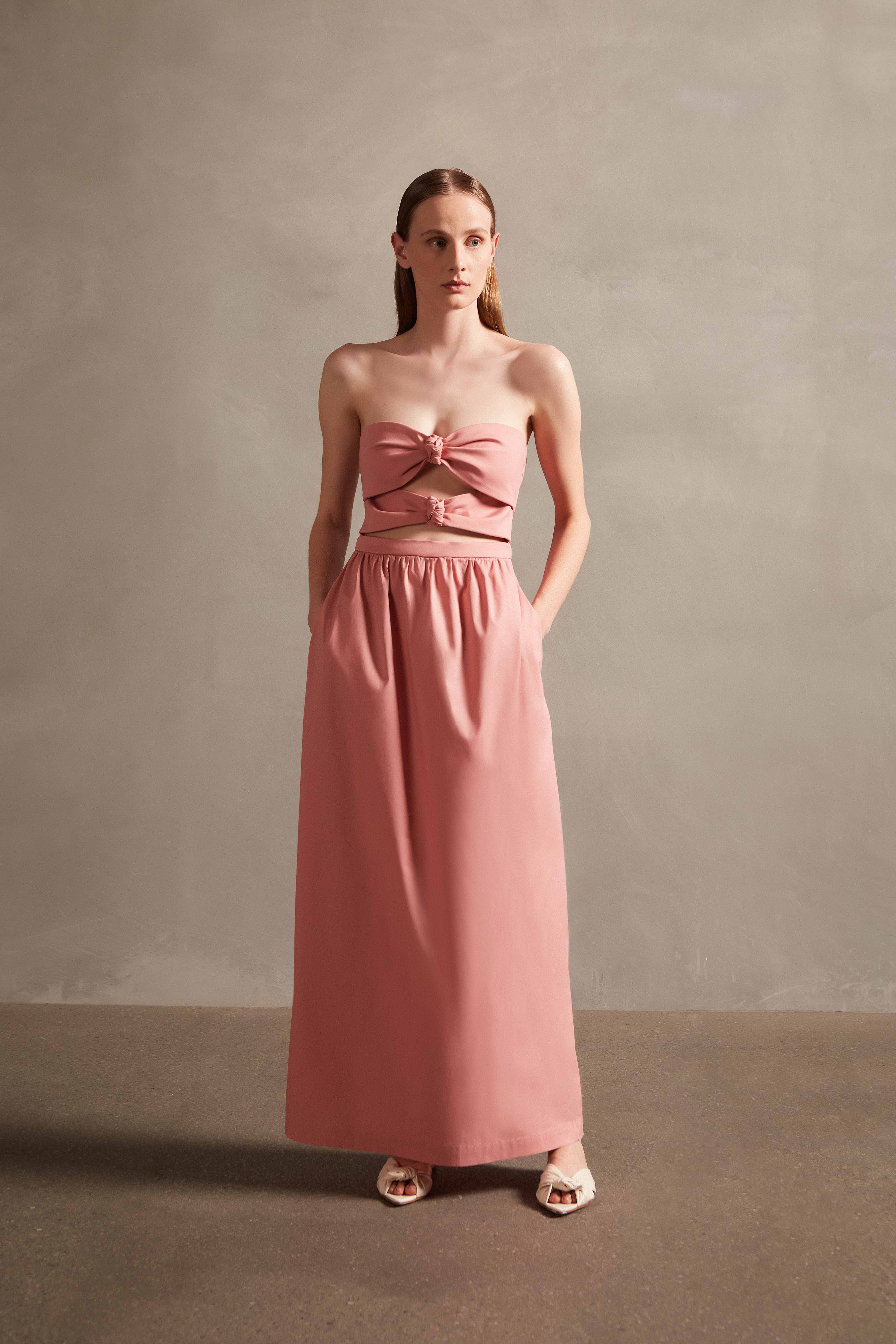 Model wearing the Exotic Coral Solid Cut-Out Long Dress Front showcasing its Pink print on 98% Polyester 2% Elastane fabric, styled for an evening look.