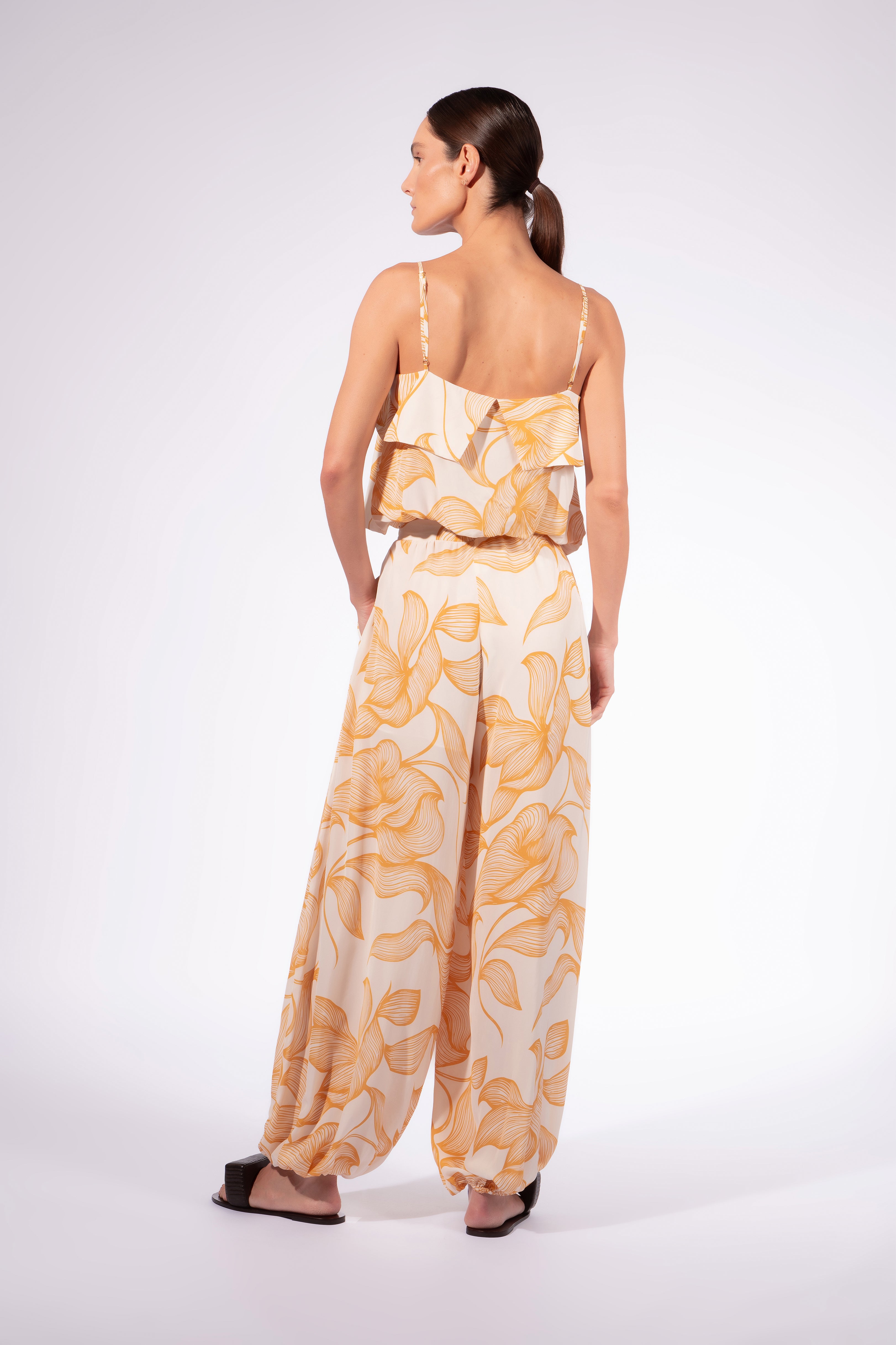 Model wearing the Foliage Bubble Pants back color cashew yellow, made from 10% viscose, styled for a resort look