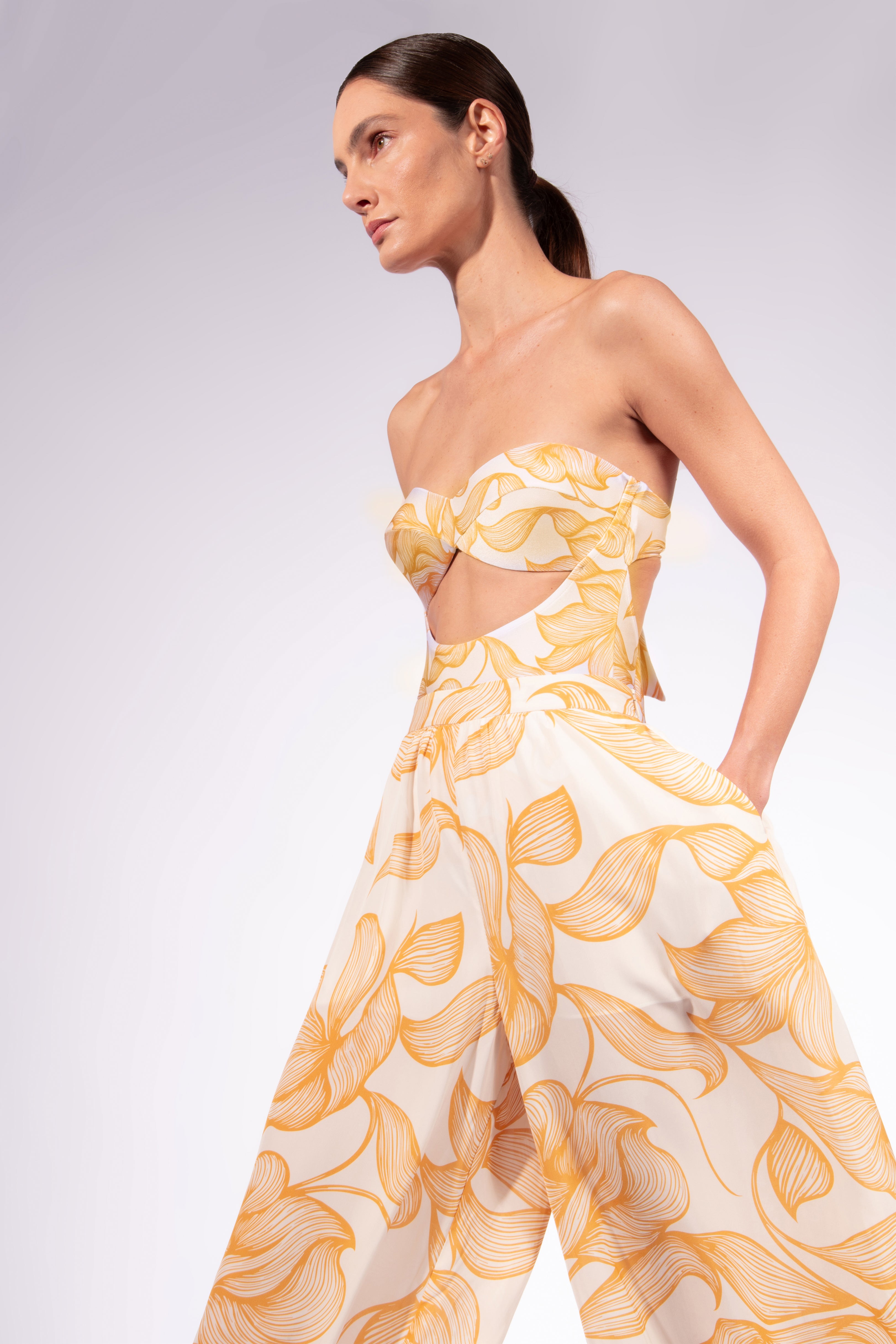 Model wearing the Foliage Bubble Pants look color cashew yellow, made from 10% viscose, styled for a resort look