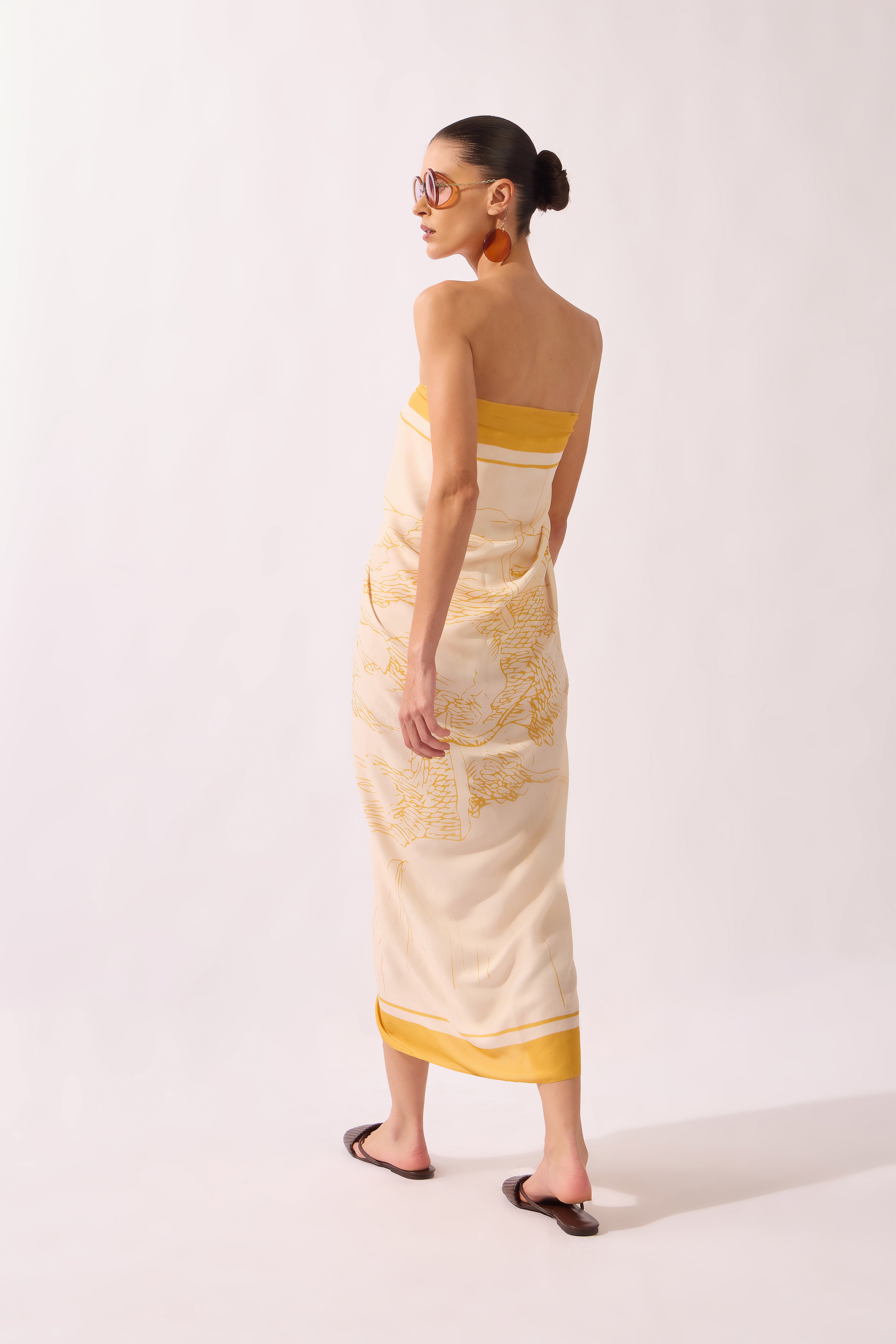 Model holding the Foliage Panneau, showcasing its yellow print on 100% viscose fabric.