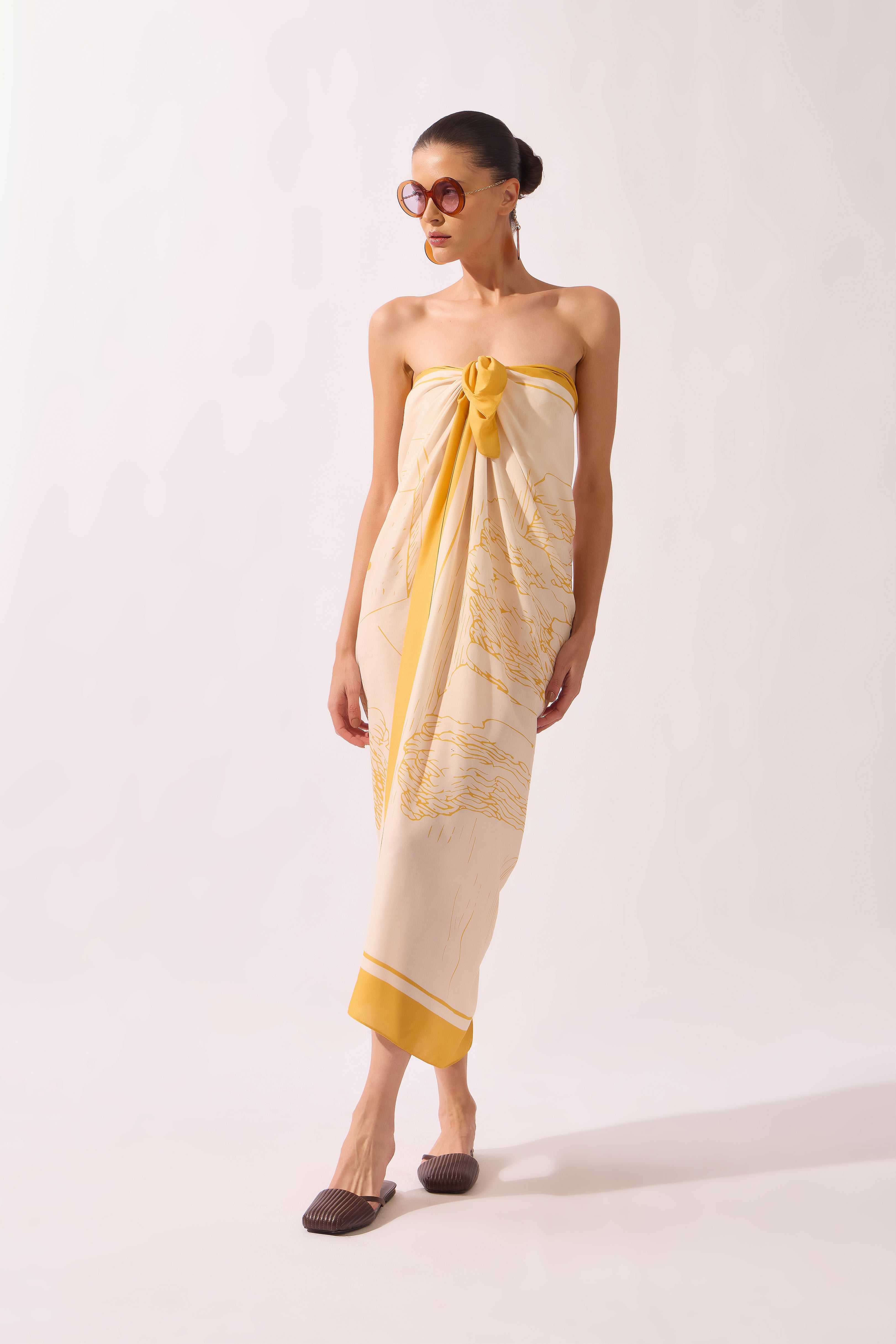 Model holding the Foliage Panneau, showcasing its yellow print on 100% viscose fabric.