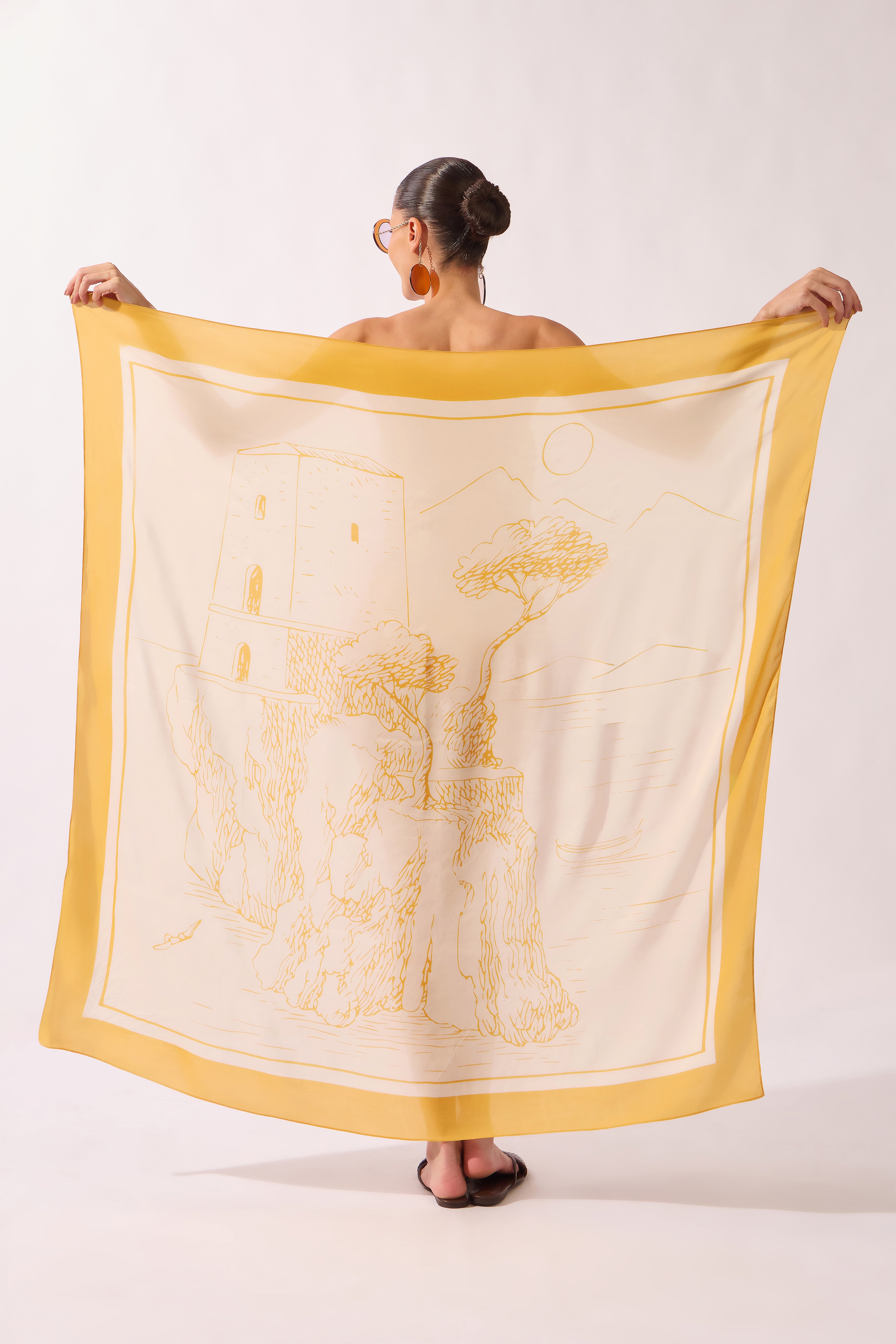 Model holding the Foliage Panneau, showcasing itsyellow print on 100% viscose fabric.