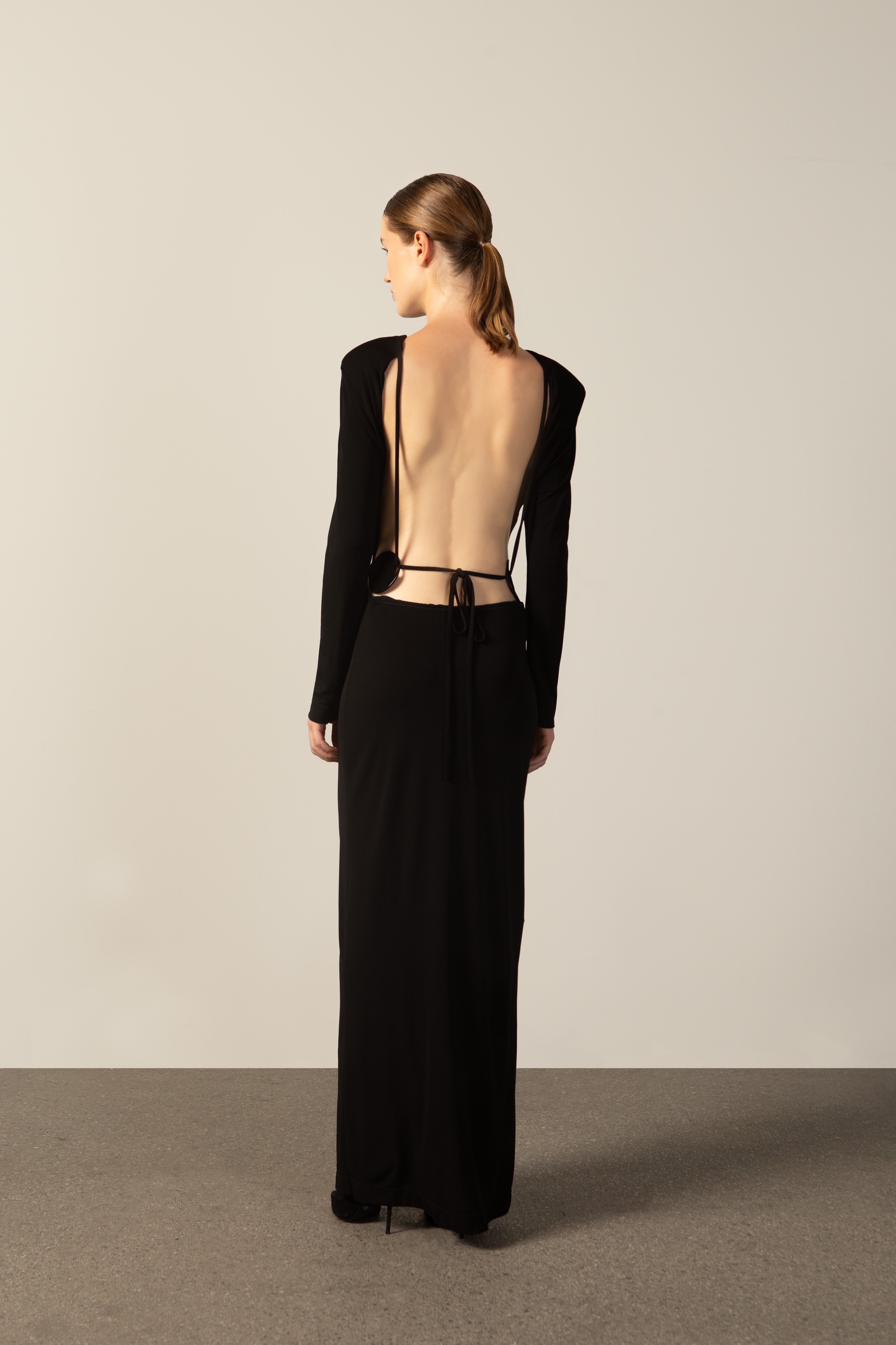Model wearing the Geometric Long-Sleeved Bare-Back Long Dress black back from the HS25 with 92% Polyester 8% Polyamide styled for a date look.