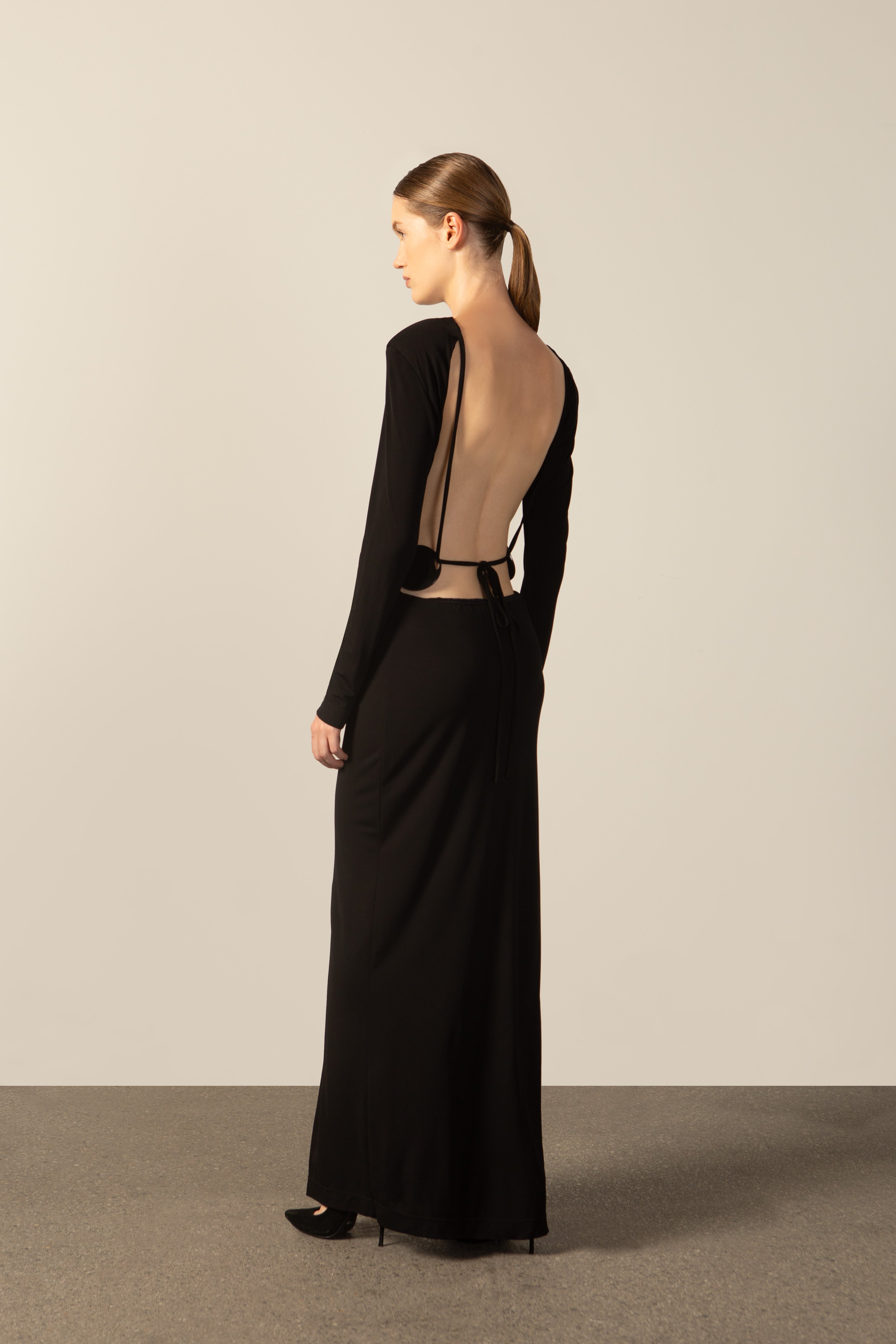 Model wearing the Geometric Long-Sleeved Bare-Back Long Dress black detail from the HS25 with 92% Polyester 8% Polyamide styled for a date look.