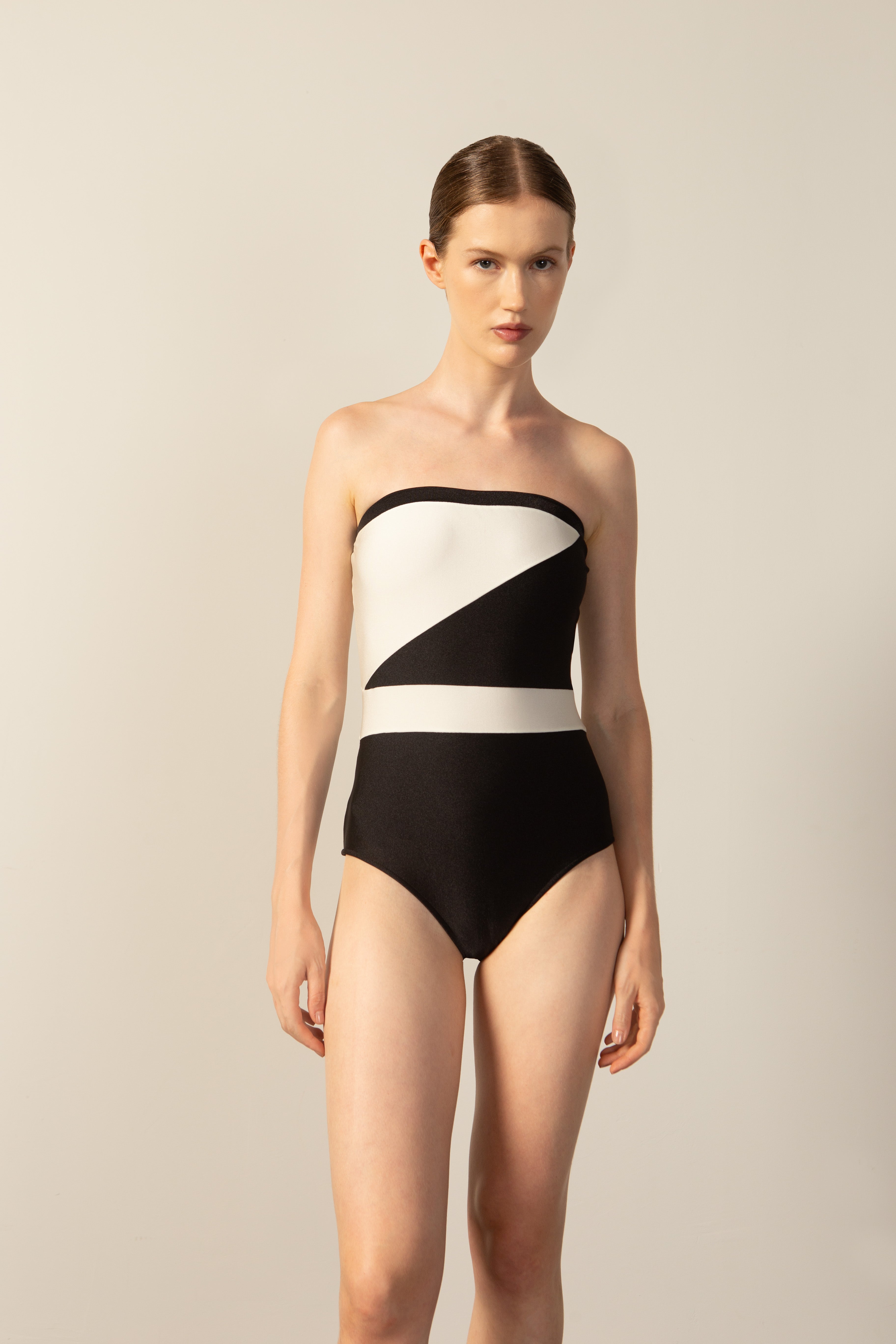 Model wearing the Geometric Strapless Swimsuit black color front from the HS25 with 85% Polyamide 15% Elastane styled for a beach look.