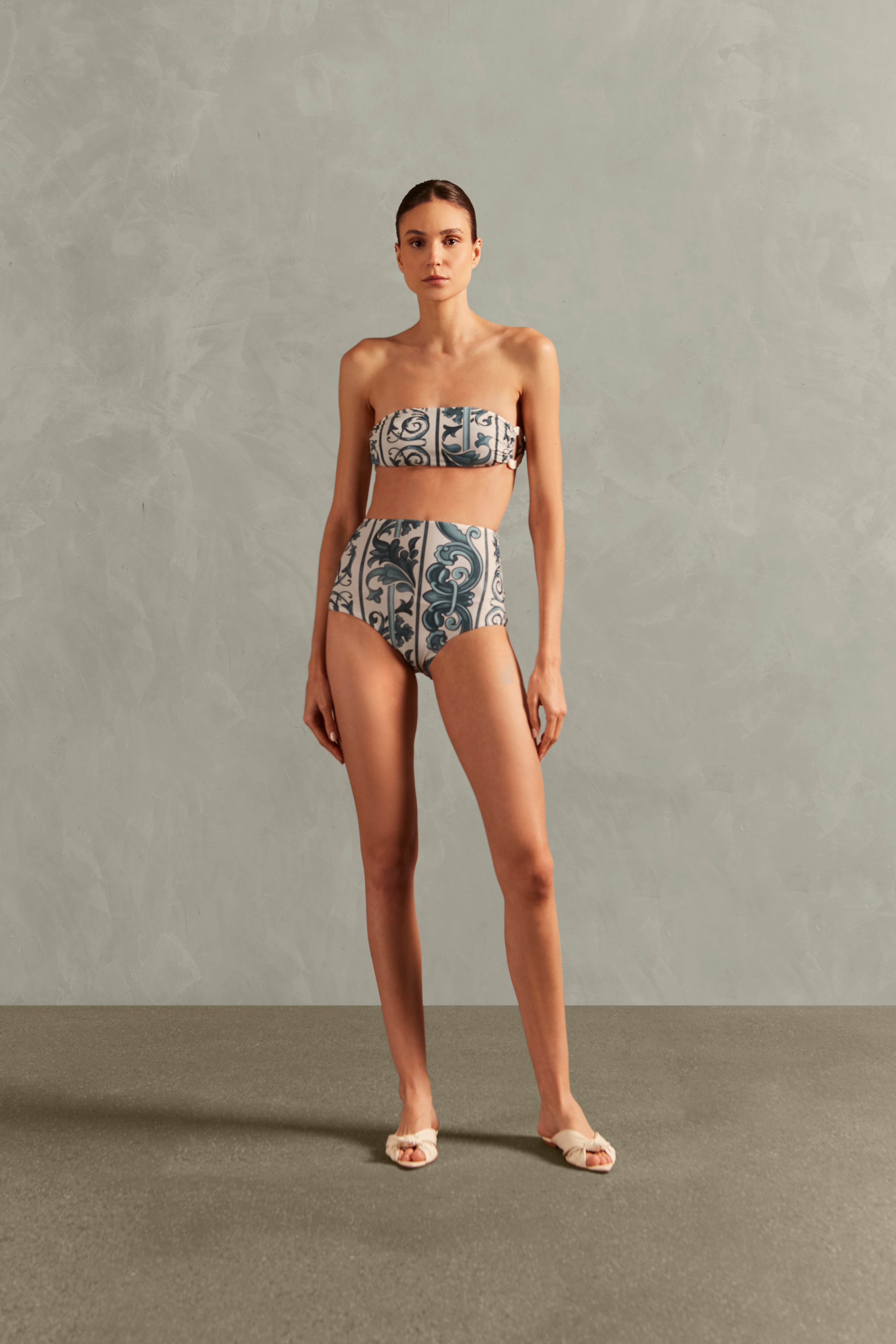 Model wearing the Hera High-Waisted Bandeau Bikini Front showcasing its Blue color on 82% polyamide 18% elastane fabric.