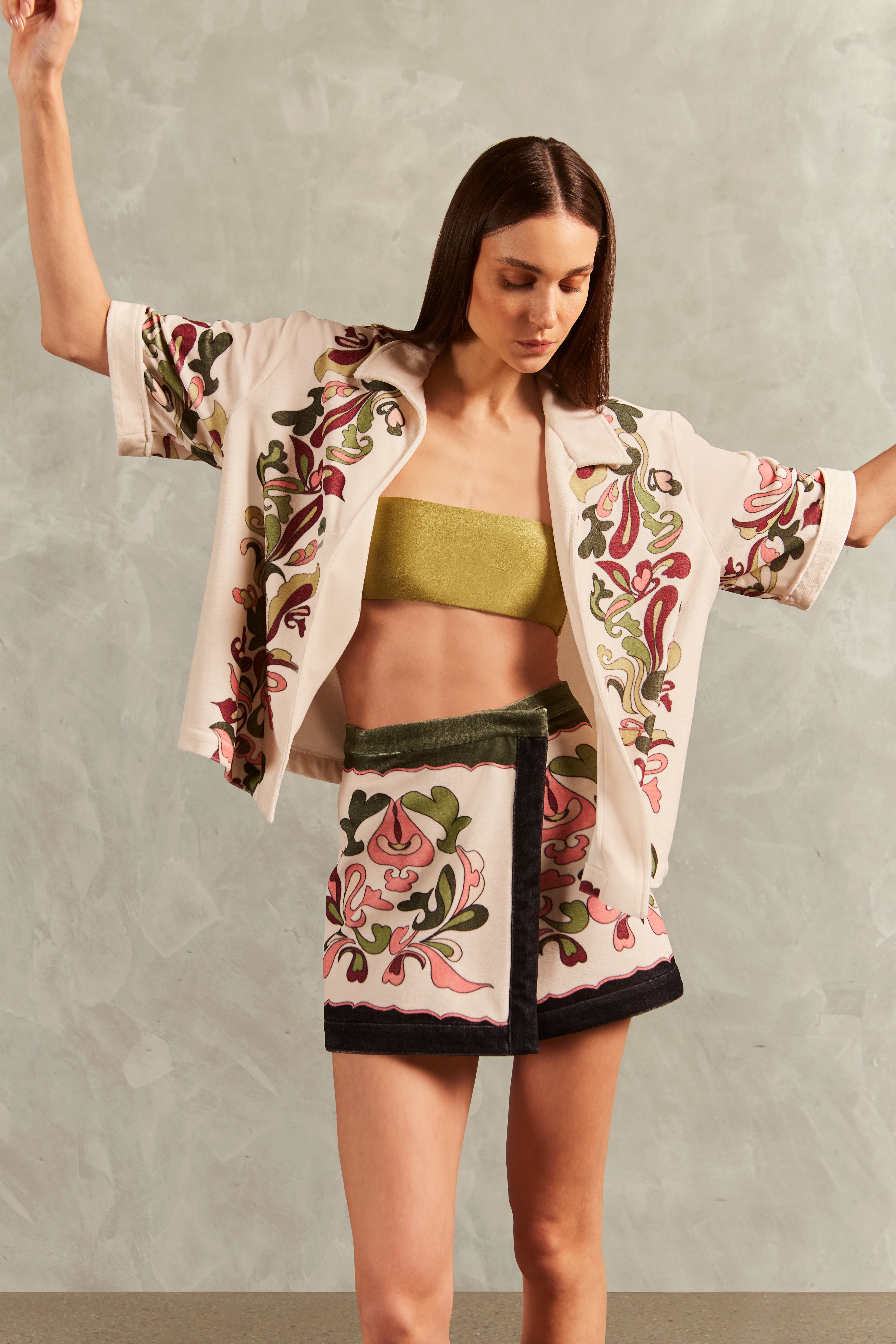 Model wearing the Inamorata Mini Skirt Concept showcasing its Off White color on 80% Cotton 20% Polyester fabric, styled for an post-beach look.