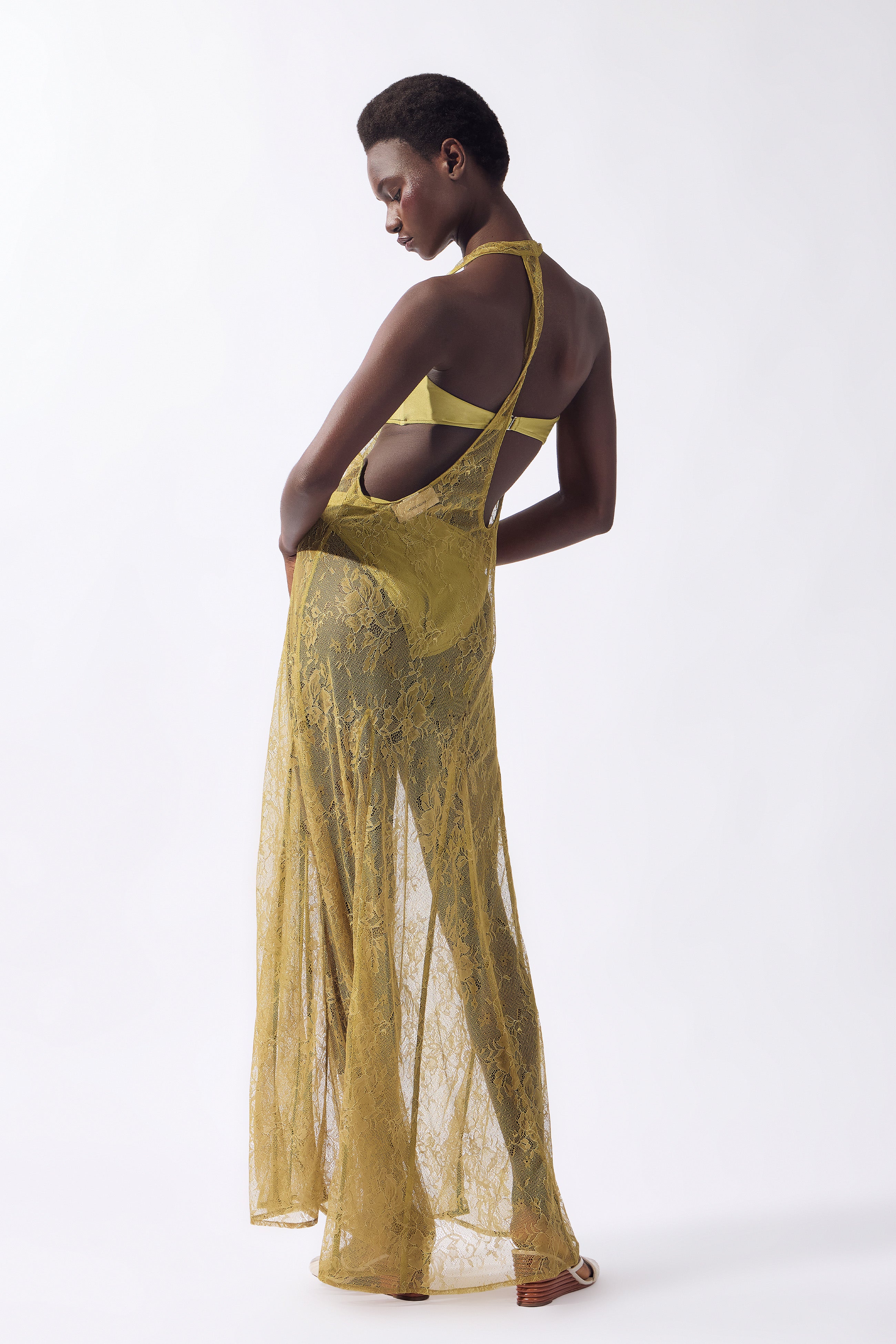 Model wearing the Lace Bare-Back Maxi Dress back color pistachio, made from 100% polyamide, styled for a post-beach look