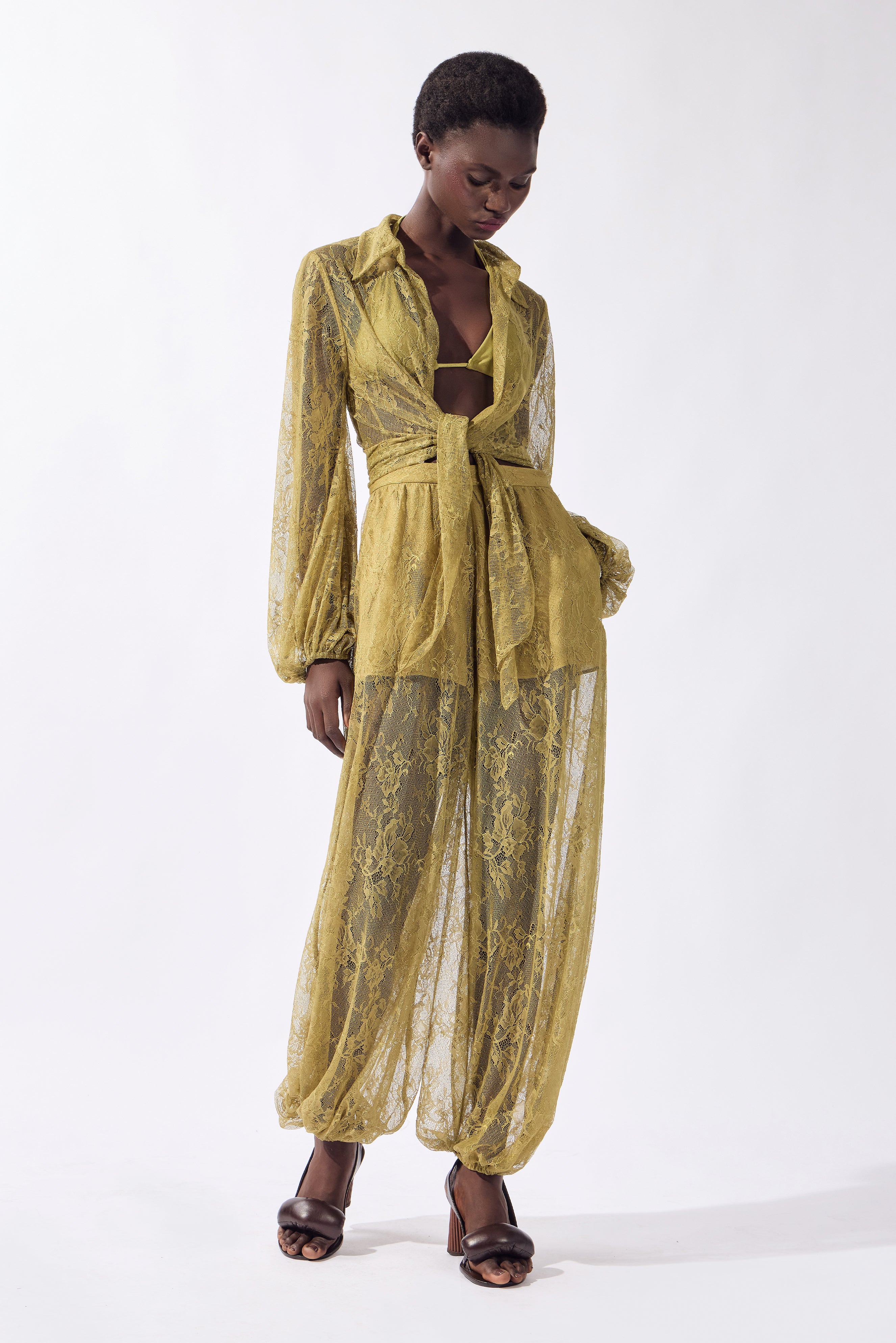 Model wearing the Lace Front-Tie Top front, color pistachio, made from 100% polyamide, styled for a resort look