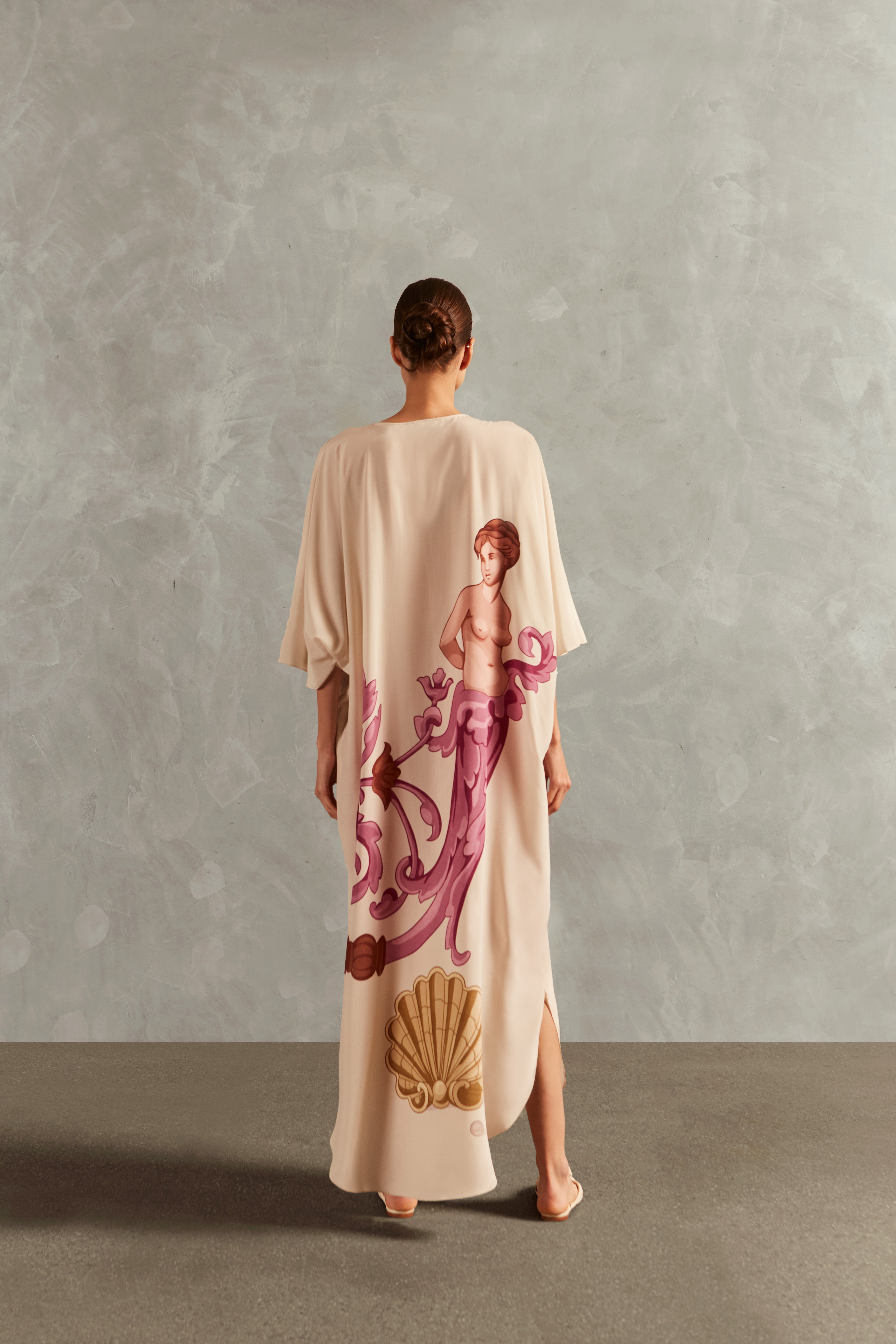 Model wearing the Le Sirenuse Buttoned Midi Kaftan Back showcasing its Lilac color on 100% Silk fabric, styled for an afternoon look.