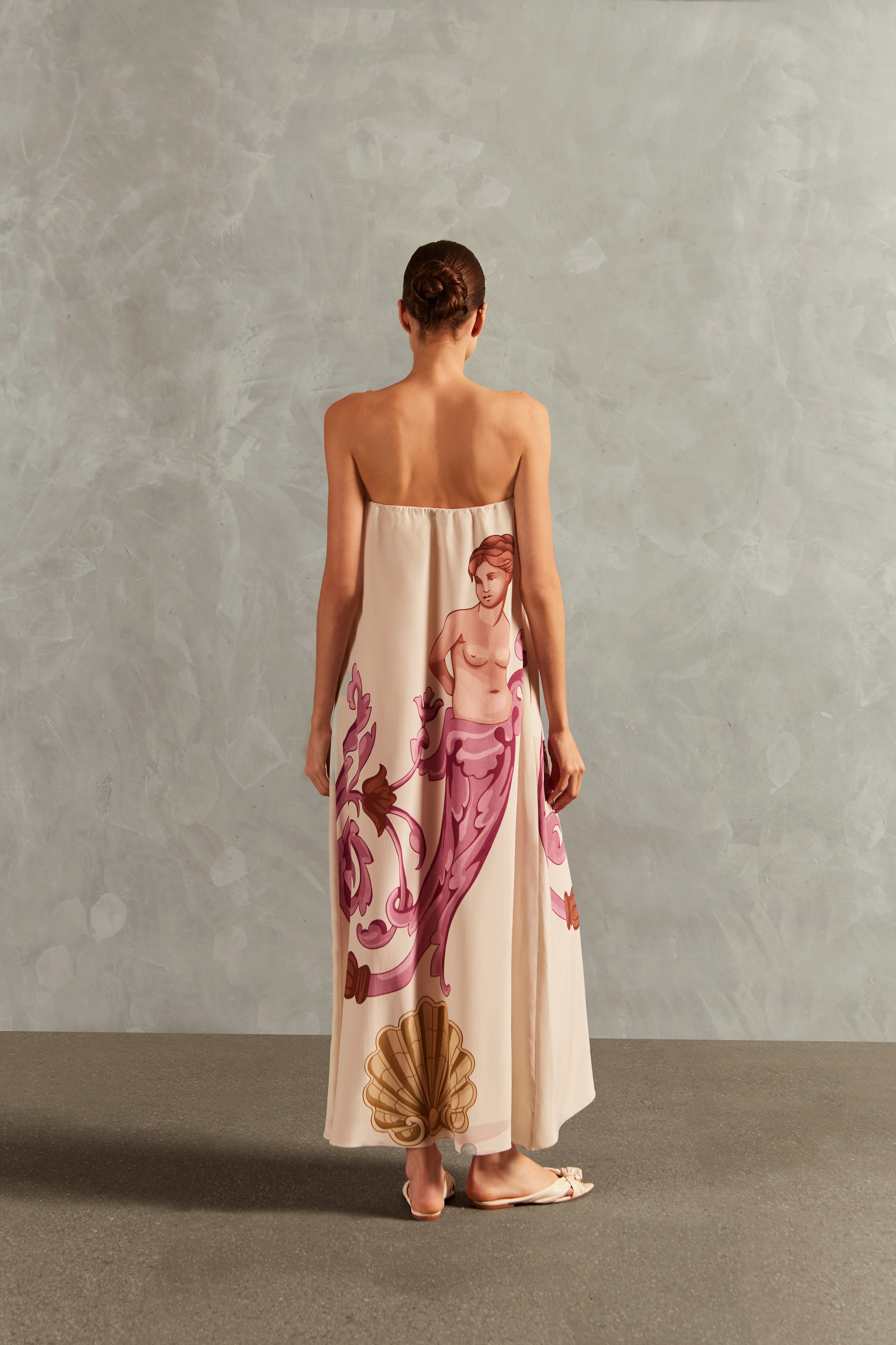 Model wearing the Le Sirenuse Strapless Long Dress Back showcasing its Lilac color on 100% Silk fabric, styled for an afternoon look.