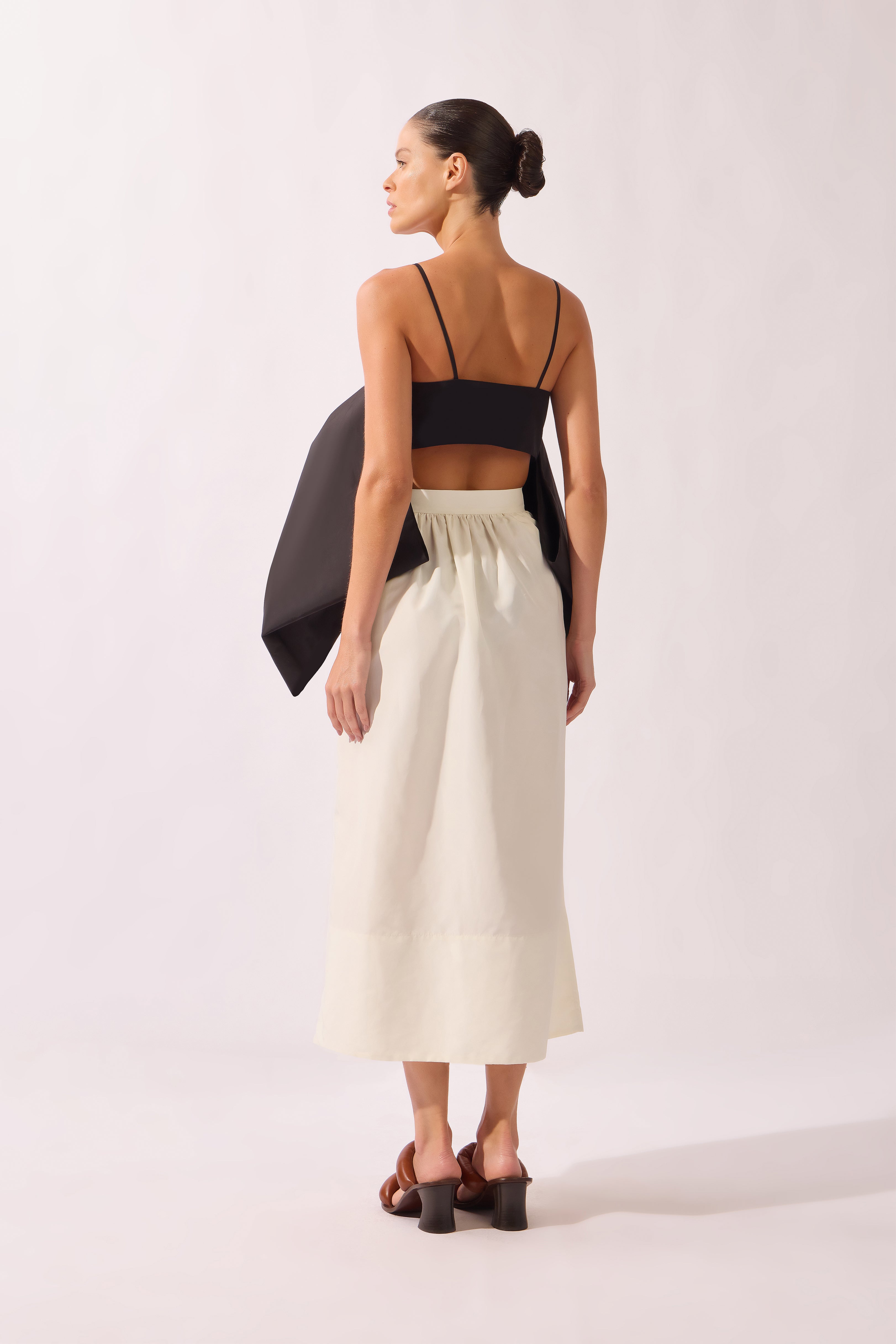 Model wearing the Solid Maxi Skirt back color black, made from 95% polyester 05% elastane, styled for a dinner look