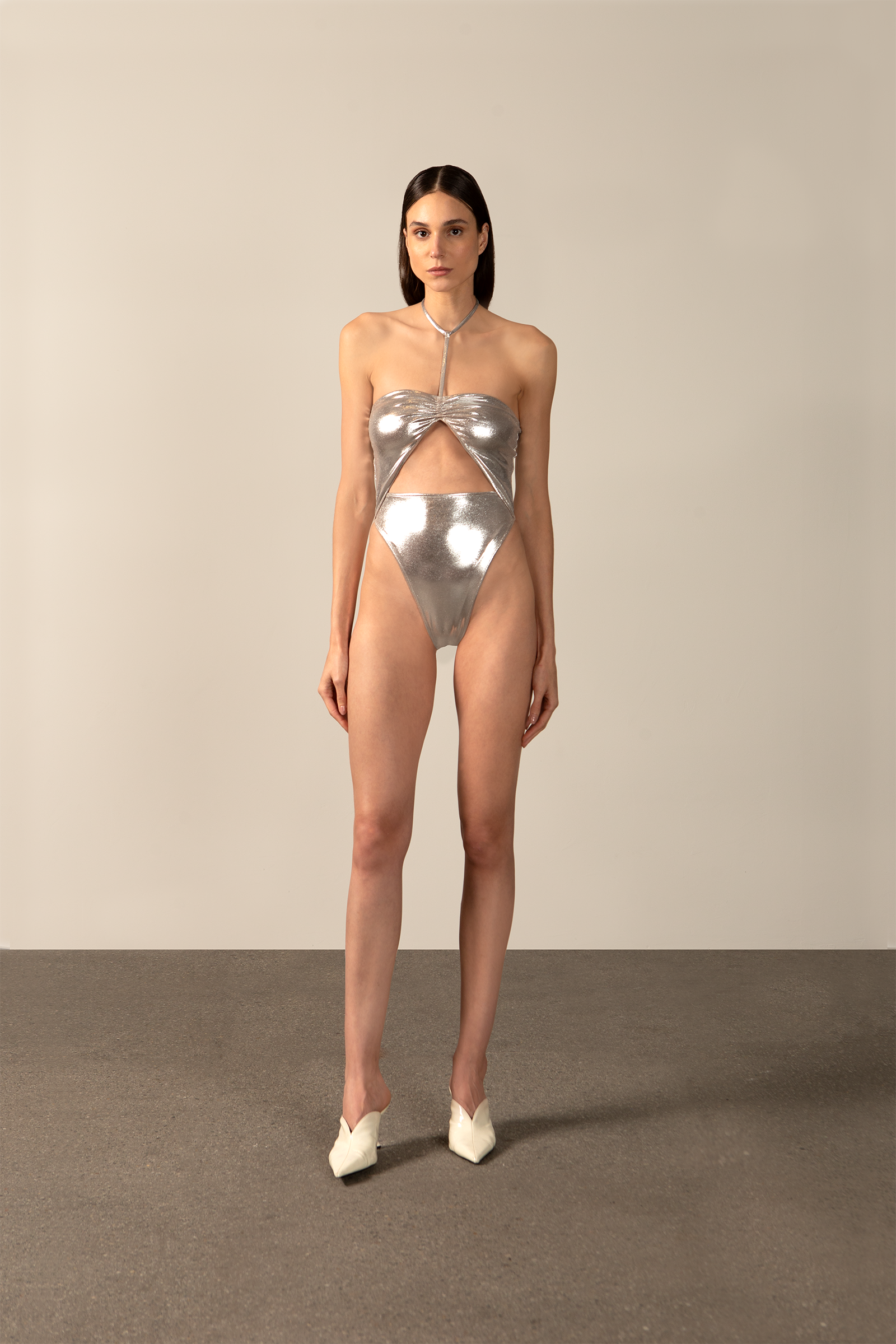Model wearing the Metallic Cut-Out Halterneck Swimsuit silver front from the HS25 with 92% POLYESTER 8% ELASTANE styled for a pool party look.