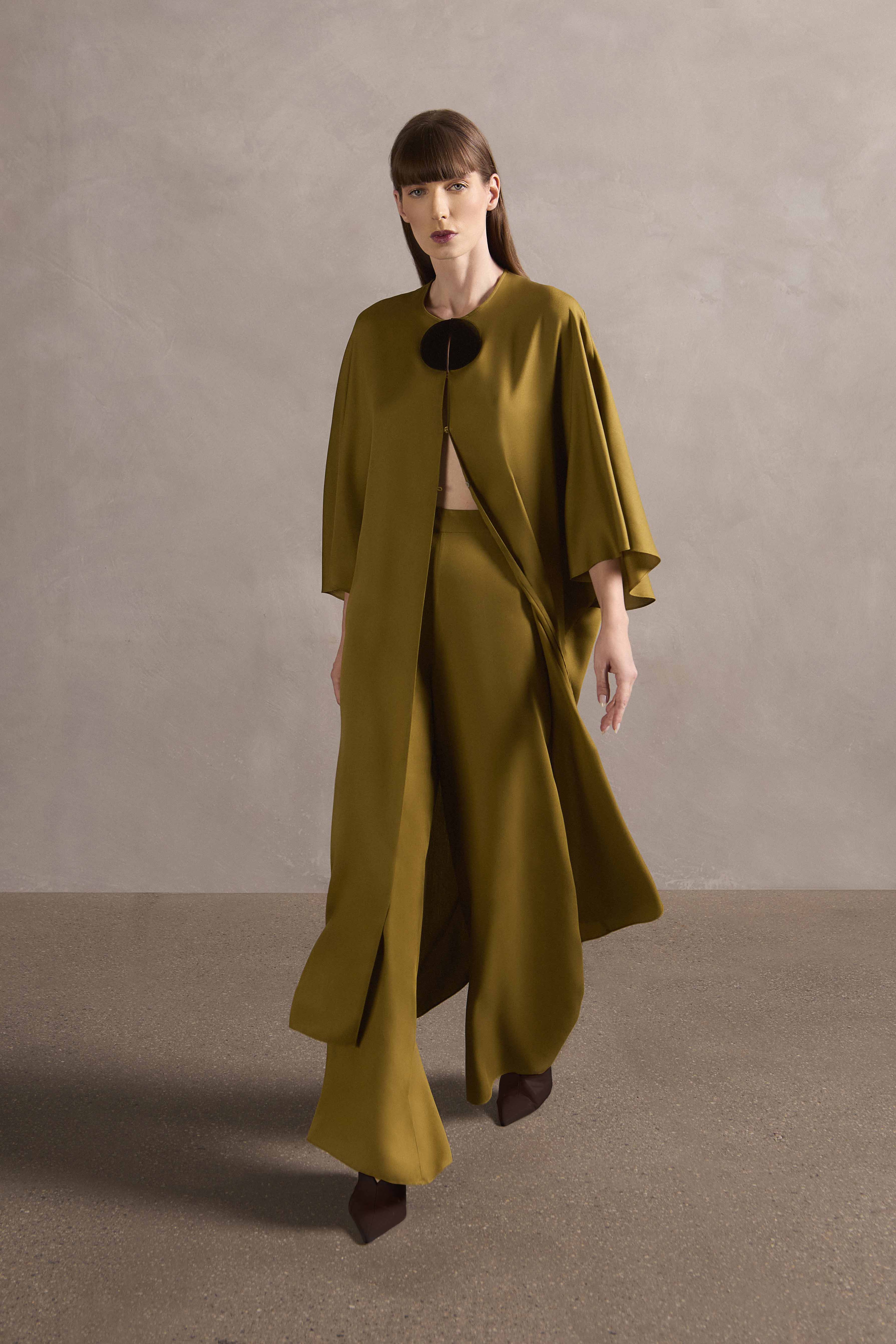 Model wearing the Mobile Wide-Leg Pants front showcasing its 70s-inspired with light green print on off-white 100% Modal fabric, used as an evening wear.