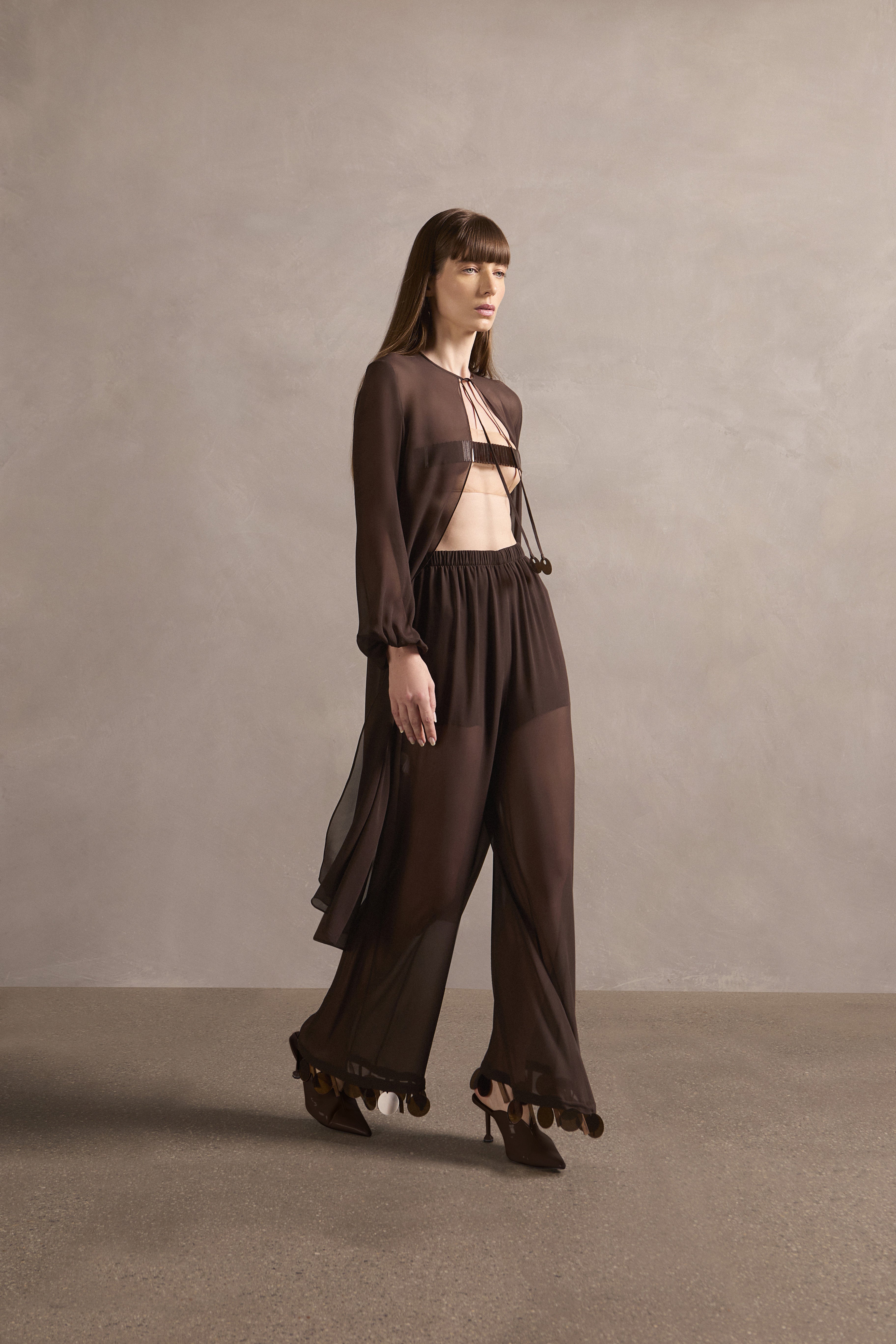 Model wearing the Mobile Wide-Leg Pants Front showcasing its contemporary elements with coffee print on 100% silk fabric used with bikini, styled for a resort look.