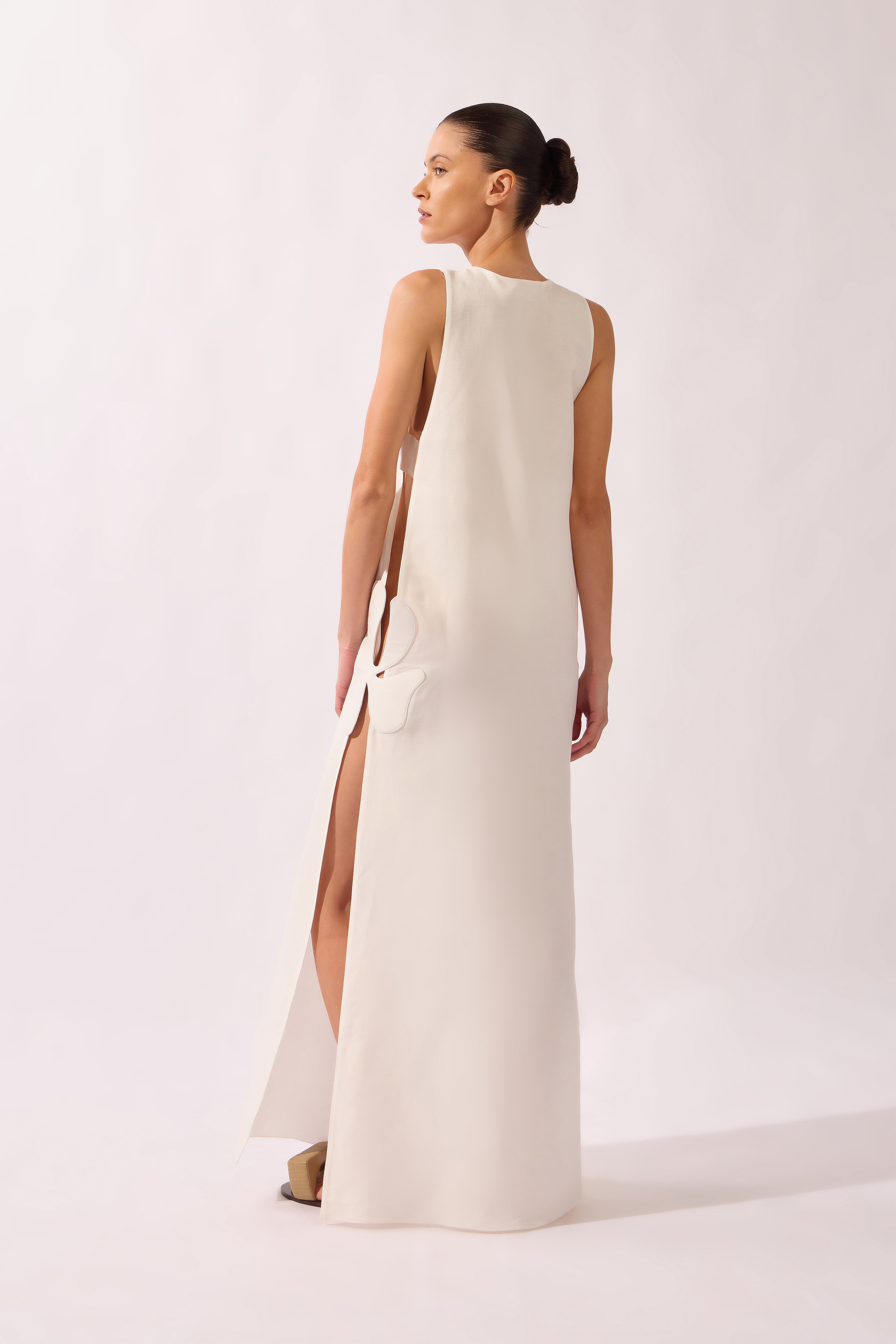 Model wearing the Open-Side Maxi Dress back color off white, made from 55% linen 45% viscose, styled for a resort look
