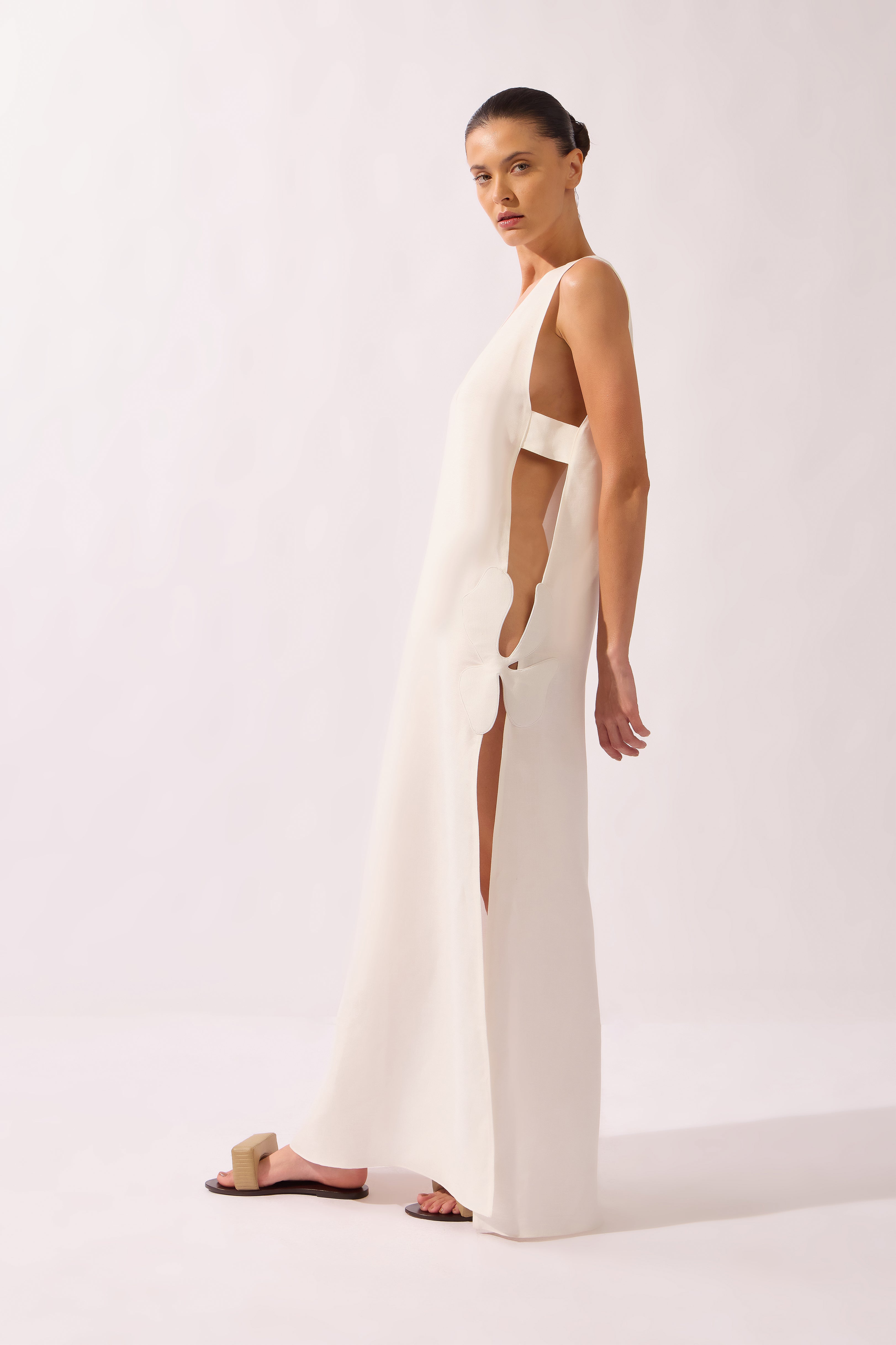 Model wearing the Open-Side Maxi Dress front color off white, made from 55% linen 45% viscose, styled for a resort look