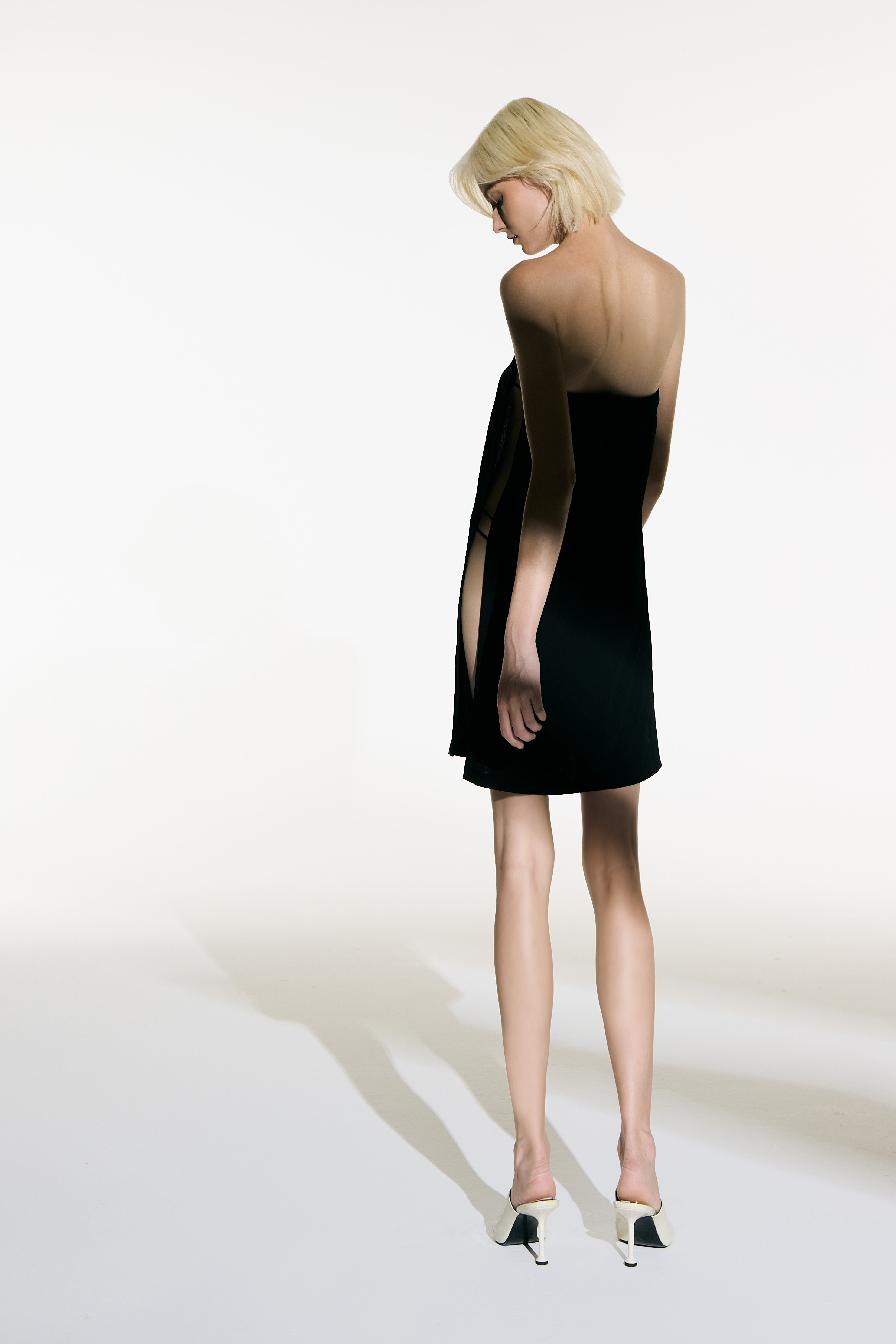 Model wearing the Open Sided Mini Dress black back from the Adriana Degreas and Sabine Getty collab with 96% Viscose 4% Elastane styled for a casual look.