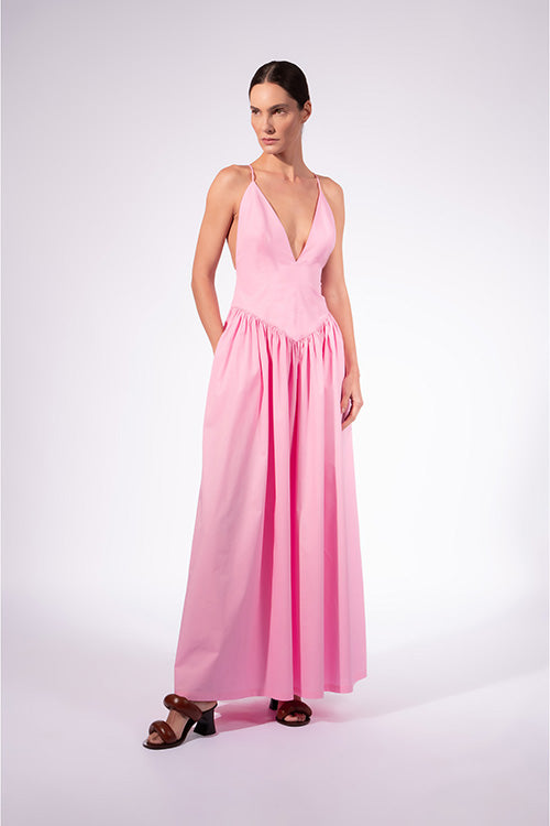 Model wearing the Opulence Deep V-Neck Maxi Dress front color light pink made with 97% Cotton 3% Elastane, styled for a dinner look
