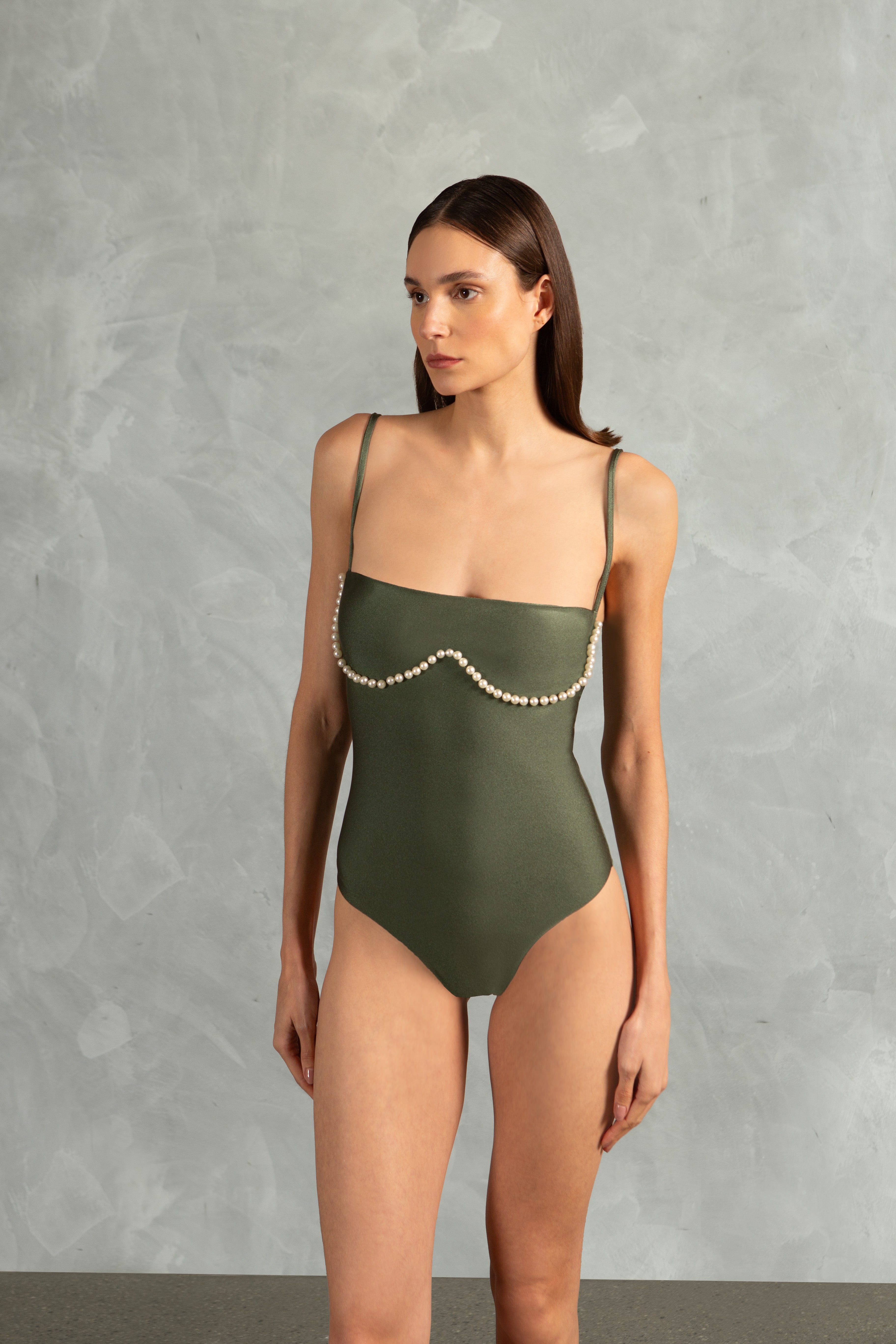 Model wearing the Oysters Solid Strapless Swimsuit With Pearls Close showcasing its Green print with Pearls Applications on 85% polyamide 15% spandex fabric, styled for a beachwear look.