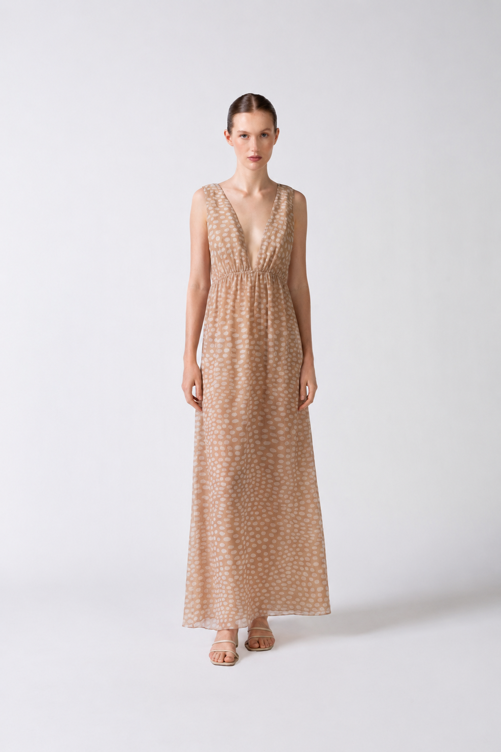 Model wearing the Pois Plunge-Neck Long Dress front color beige, made from 100% silk, styled for a night out look