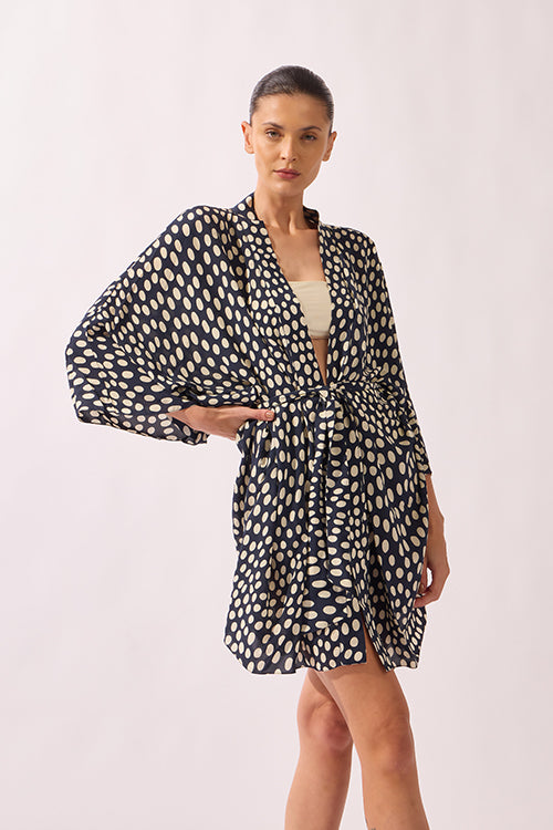 Model wearing Pois Short Robe front color navy, made from 100% viscose, styled for a resort look