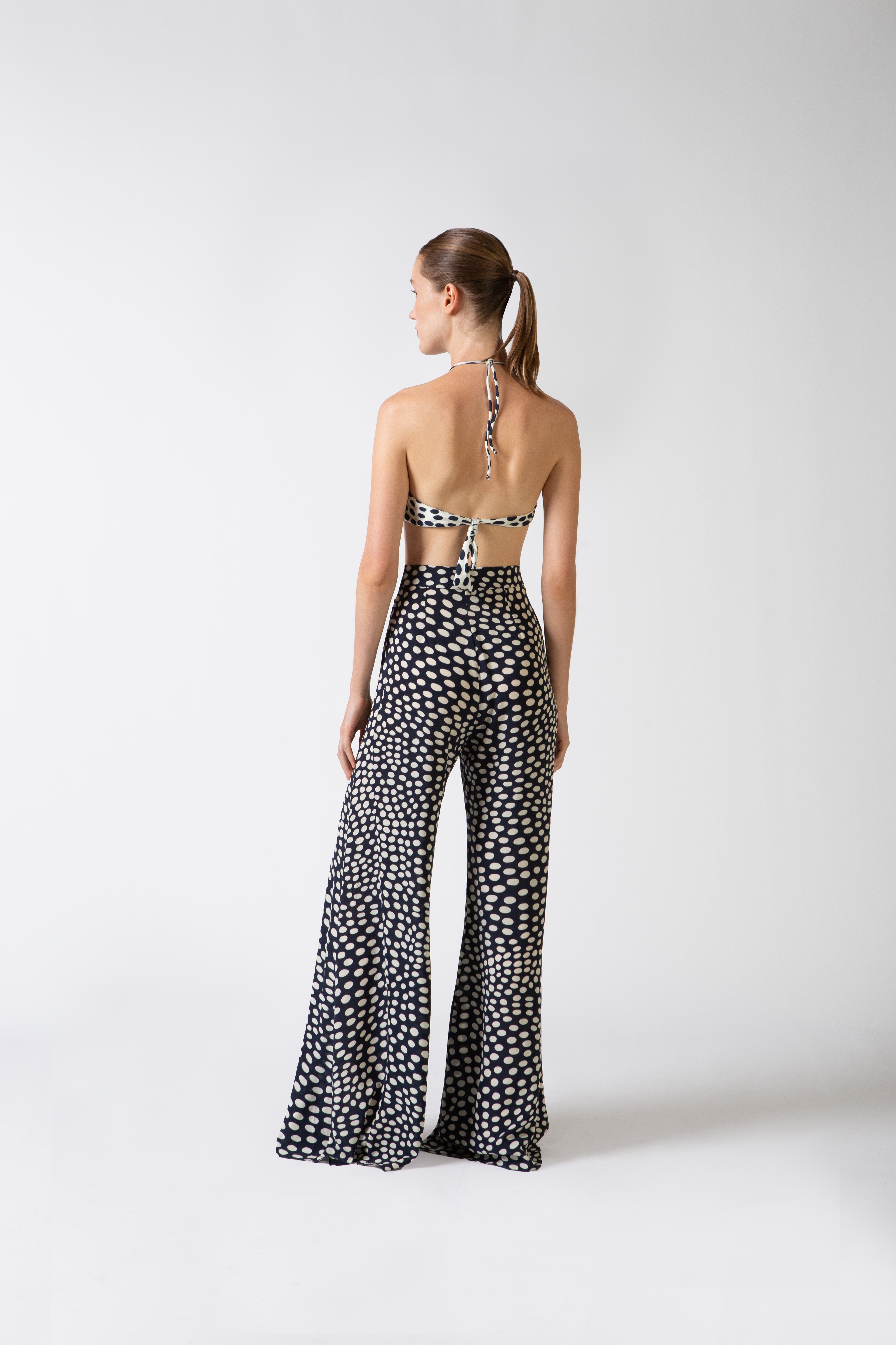 Model wearing the Pois Wide-Leg Pants navy back from the HS25 with 100% viscose styled for a beach look.