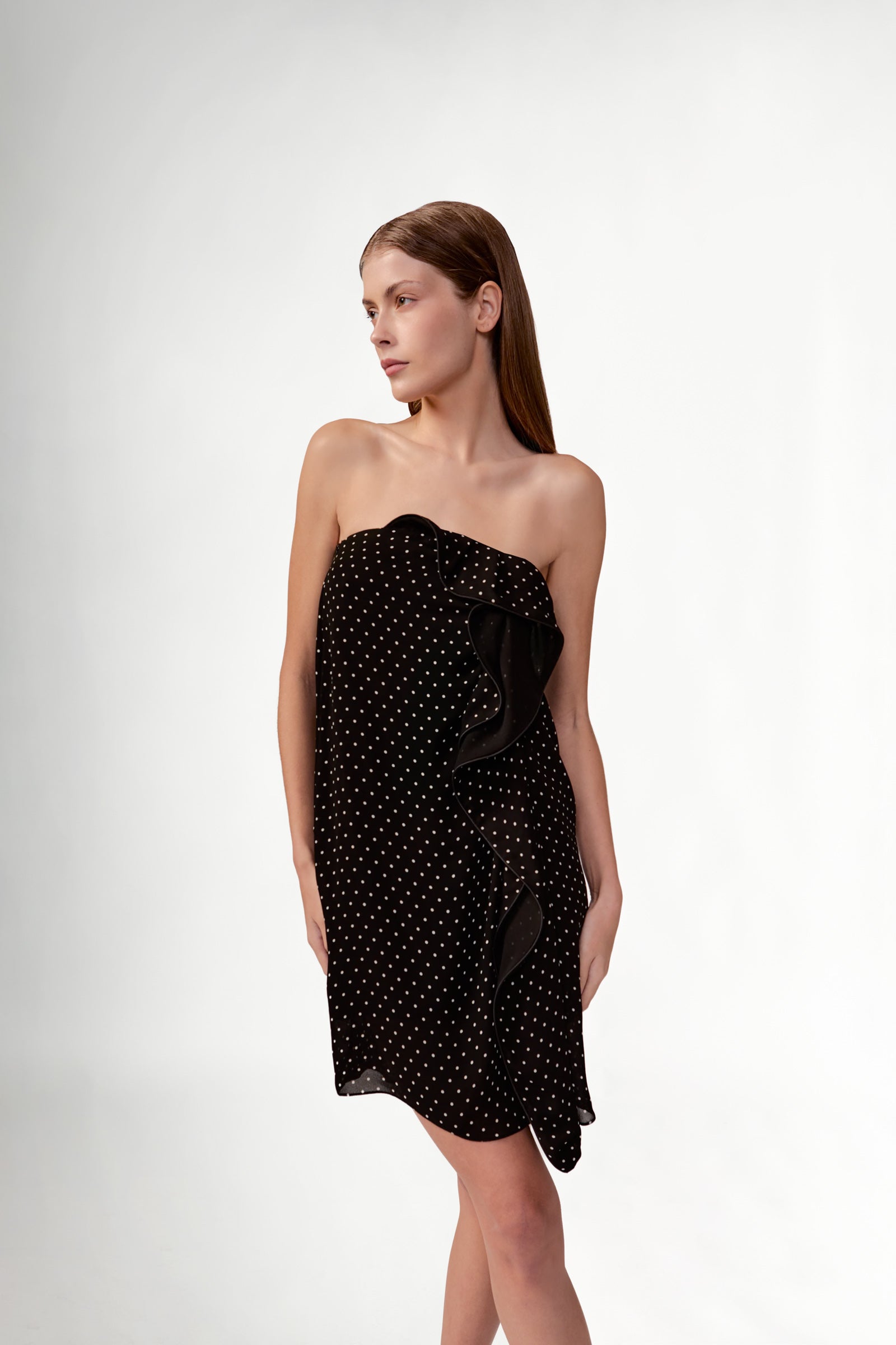 Model wearing the Polka Dots Mini Dress detail color black, made with 100% viscose fabric, styled for resortwear look