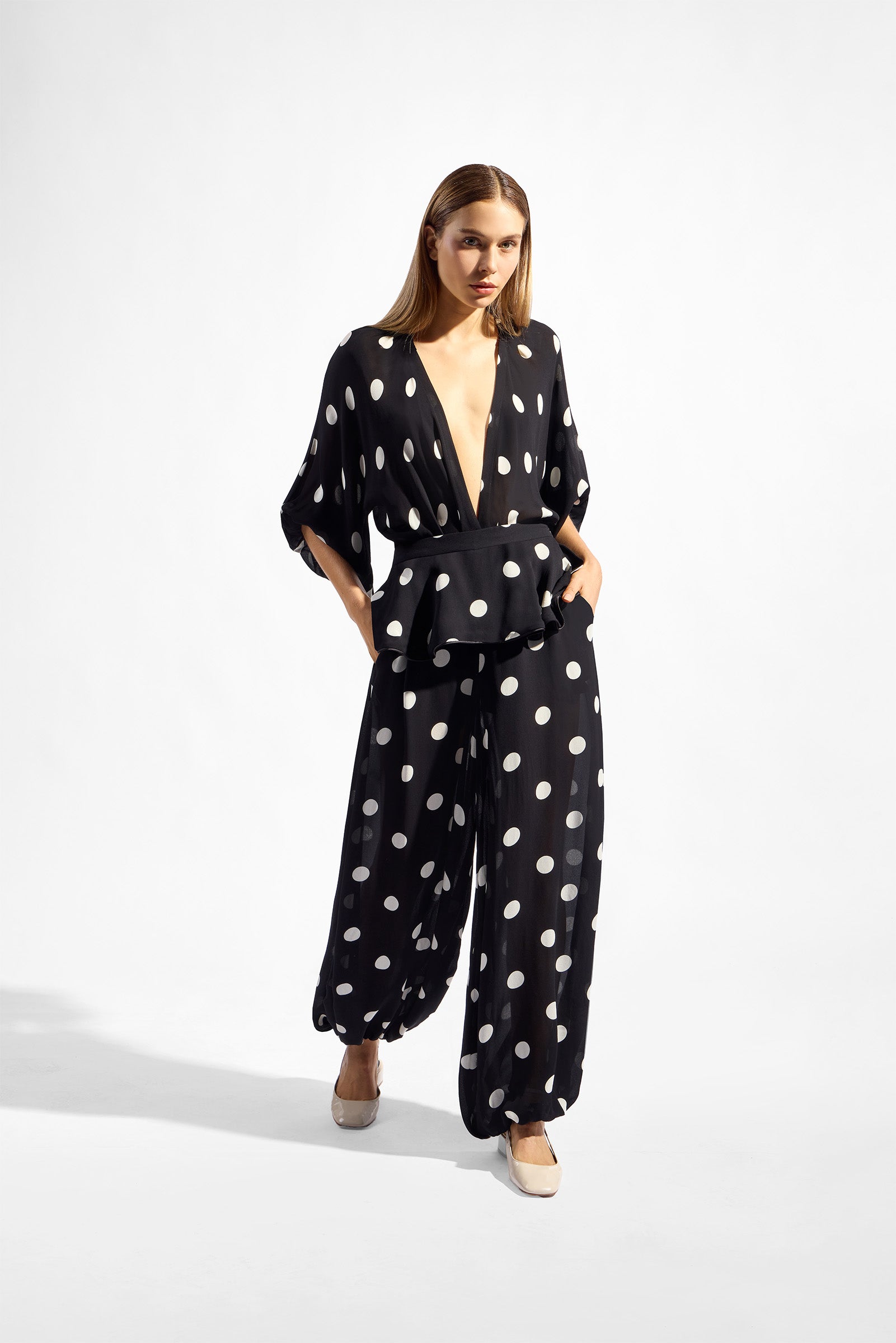 Model wearing the Polka Dots Peplum Maxi Pants front color black made with 100% viscose, styled for resortwear look