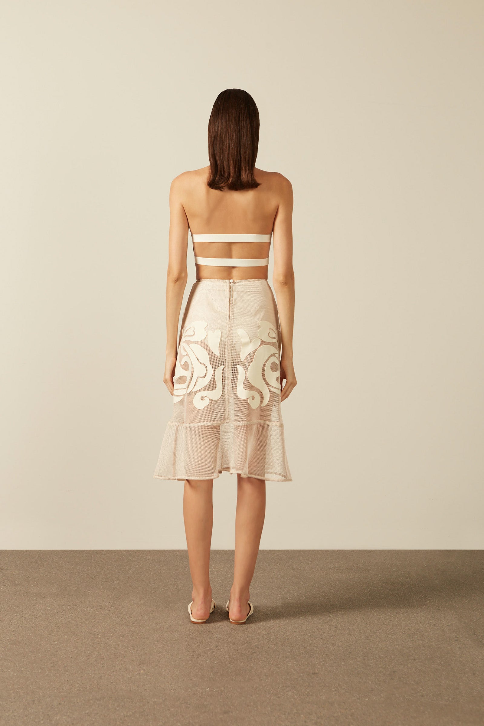 Model wearing the Réseau Appliqué Midi Skirt Back showcasing its Off White color on 100% Polyester fabric.