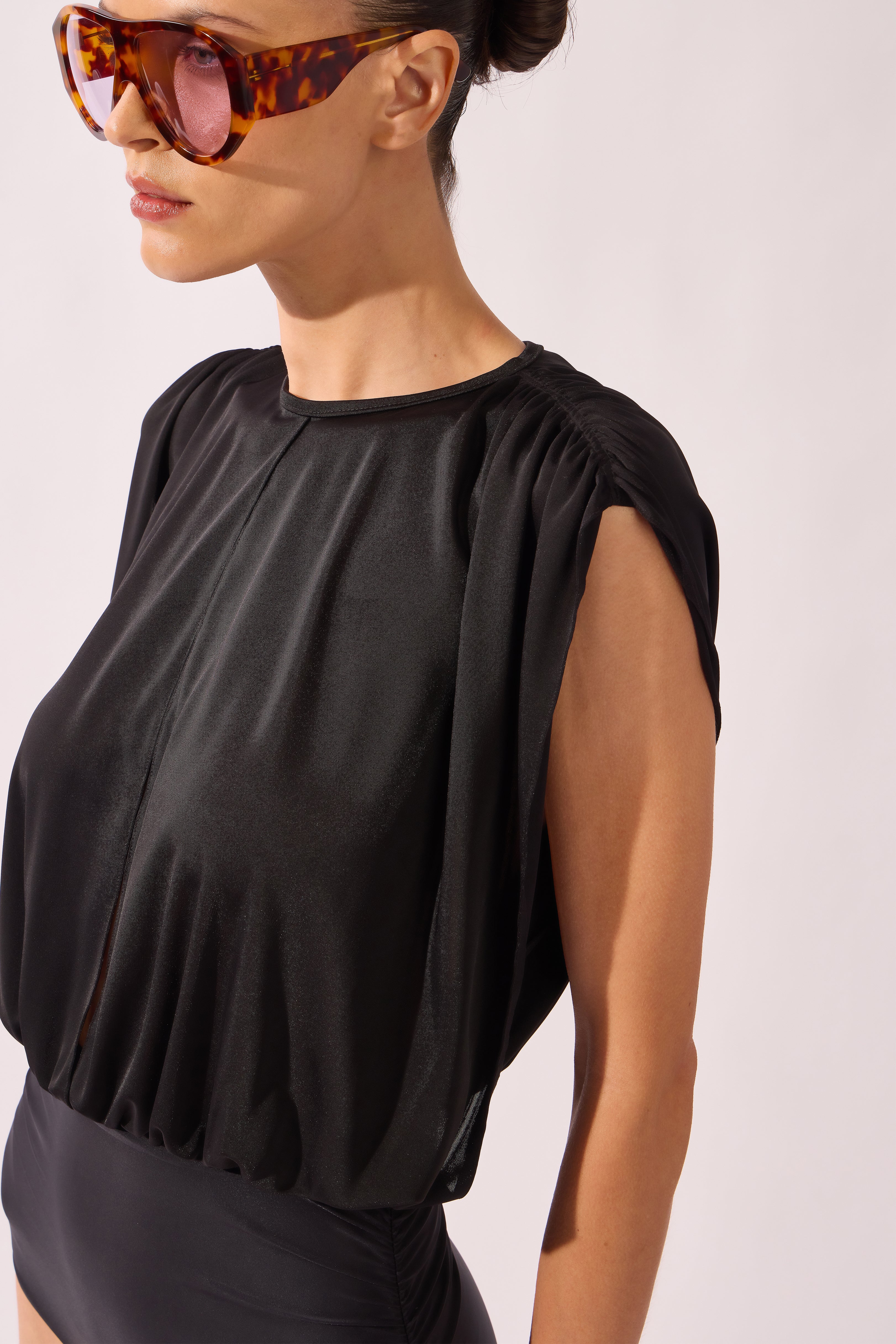 Model wearing the Ruched Swimsuit detail material color black, made from 100% polyamide, styled for a beachwear look