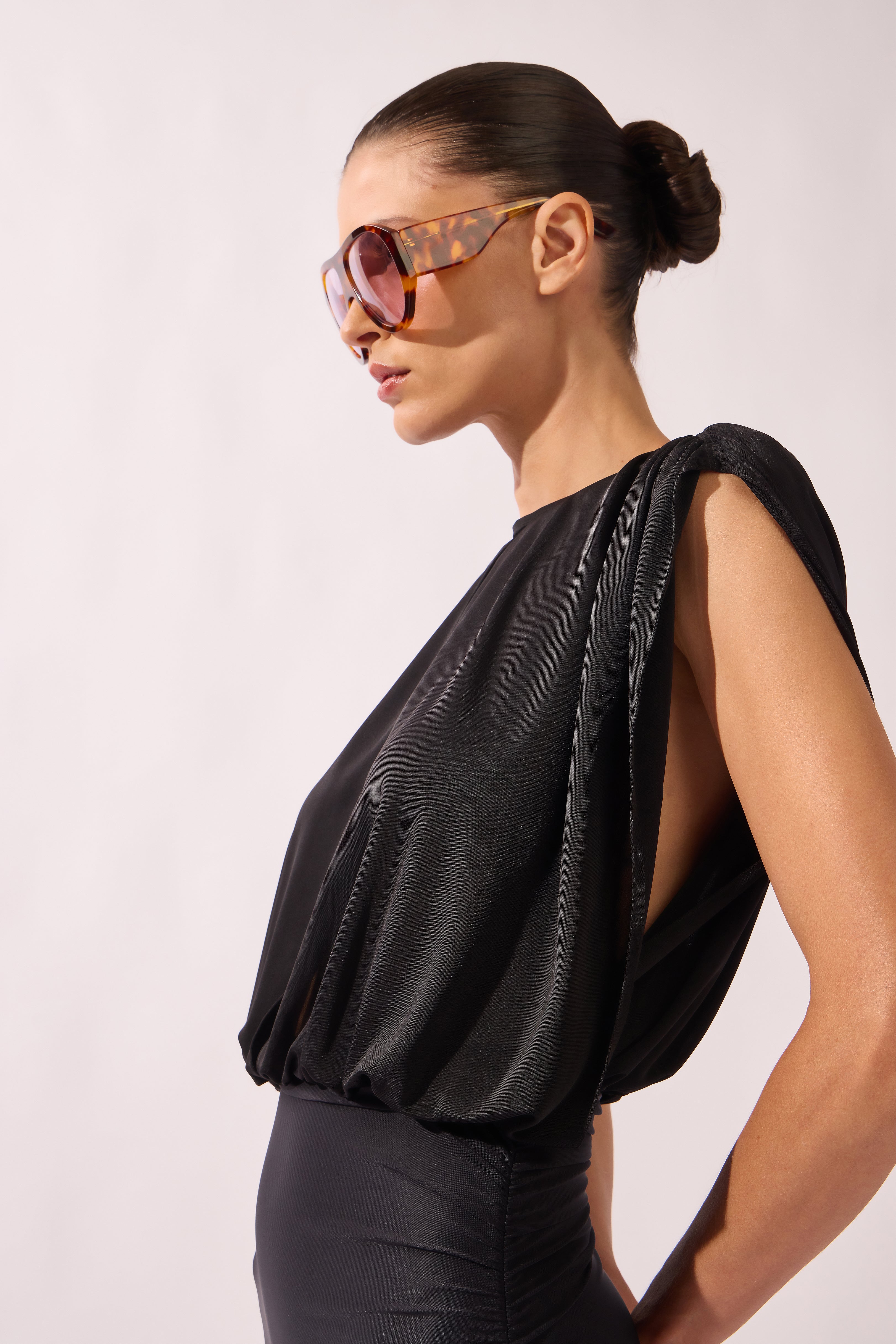 Model wearing the Ruched Swimsuit detail side color black, made from 100% polyamide, styled for a beachwear look