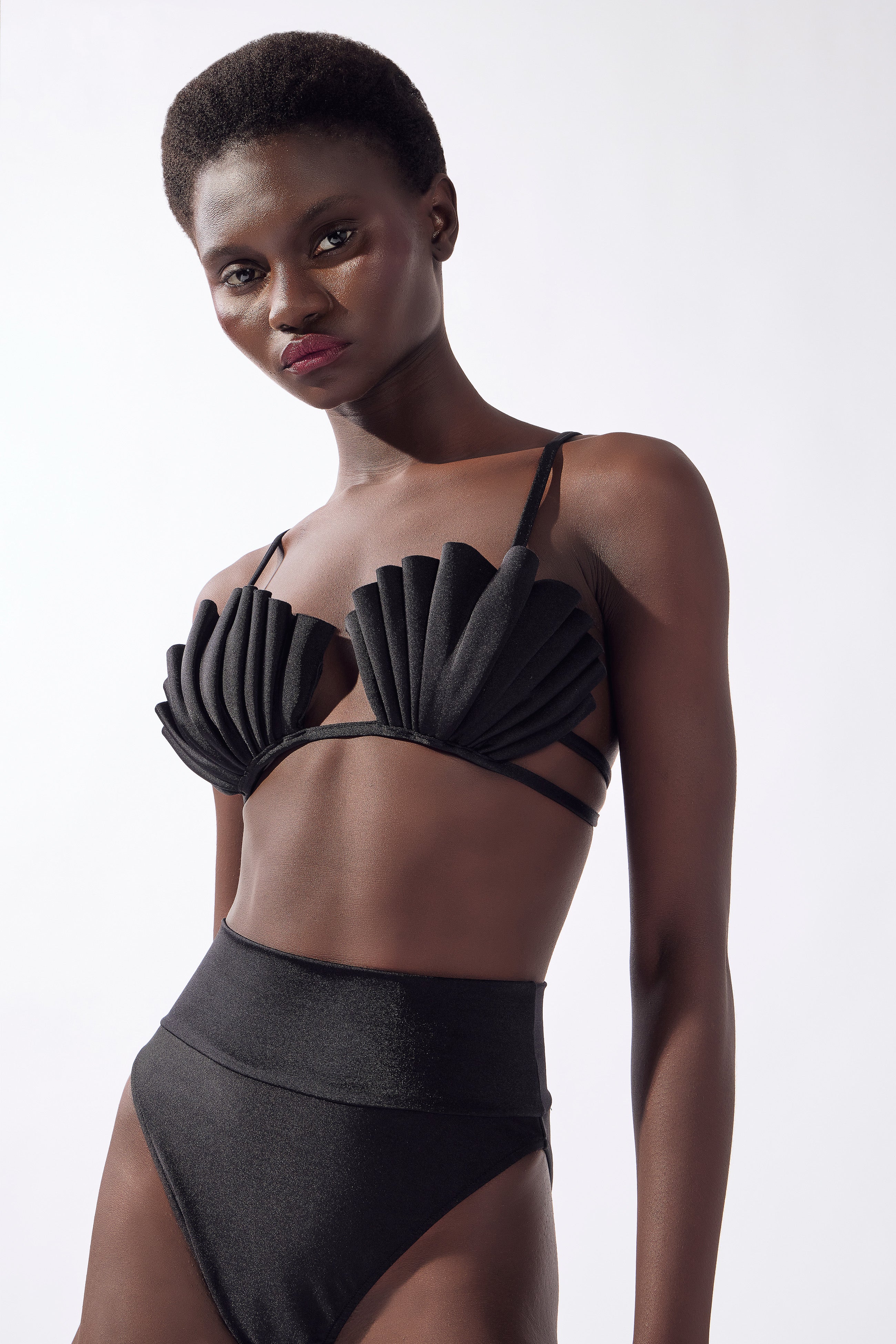 Model wearing the Seashell High-Leg Bikini Set color black made from 85% polyamide, 15% elastane, styled for a beachwear look