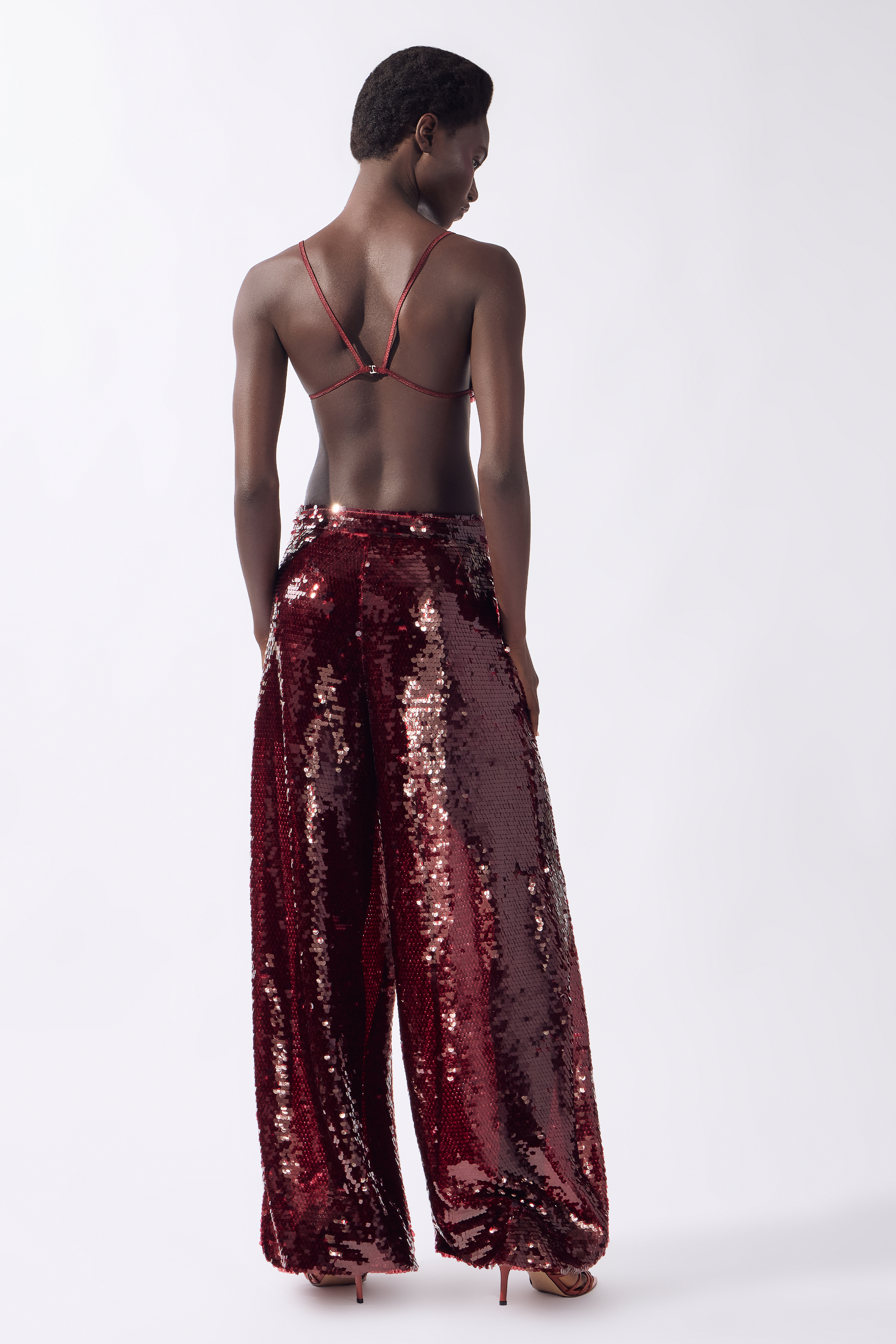 Model wearing the Sequin Bubble Pants color burgundy, made from 100% polyester, styled for a festive look