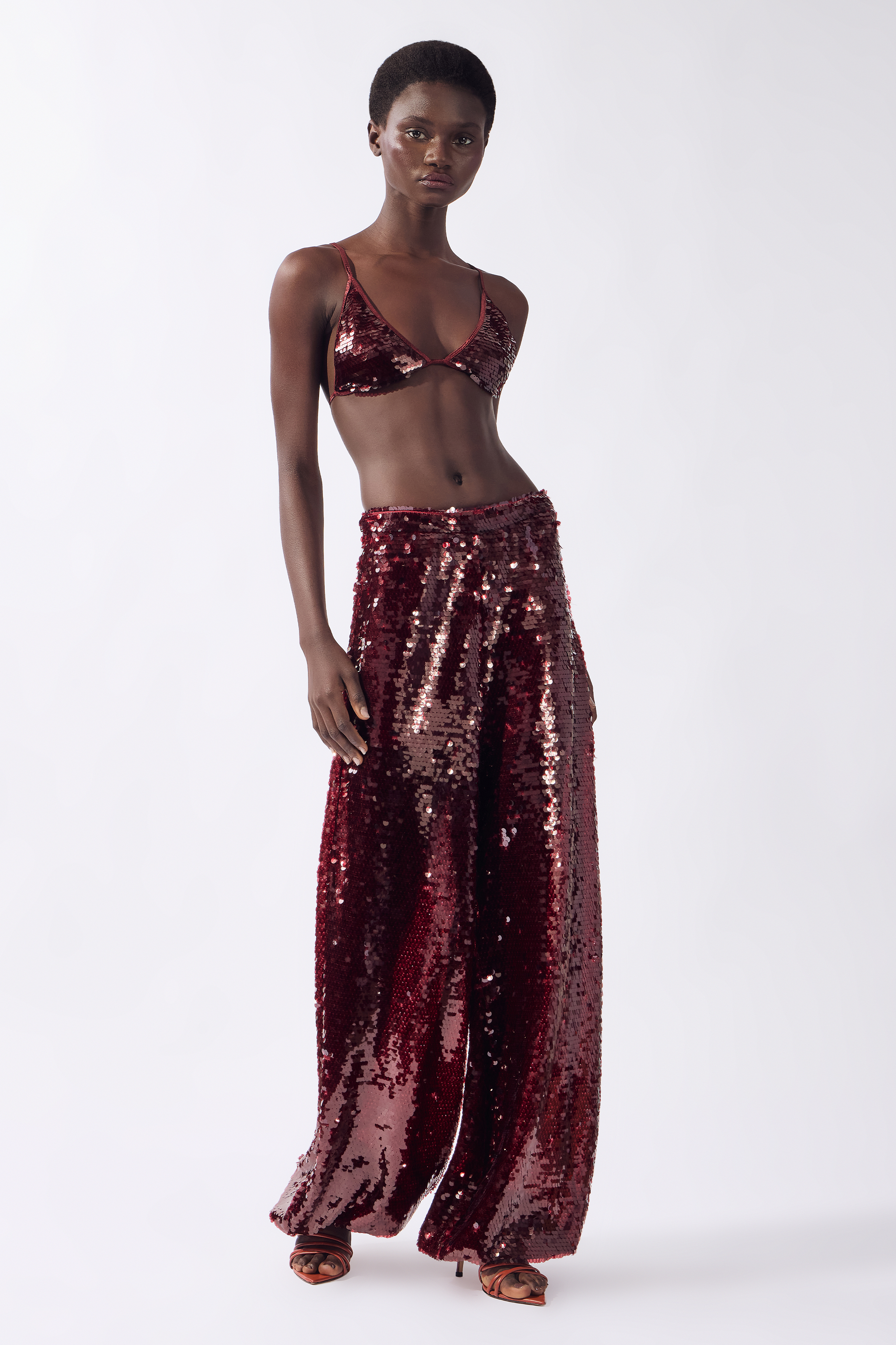 Model wearing the Sequin Bubble Pants color burgundy, made from 100% polyester, styled for a festive look