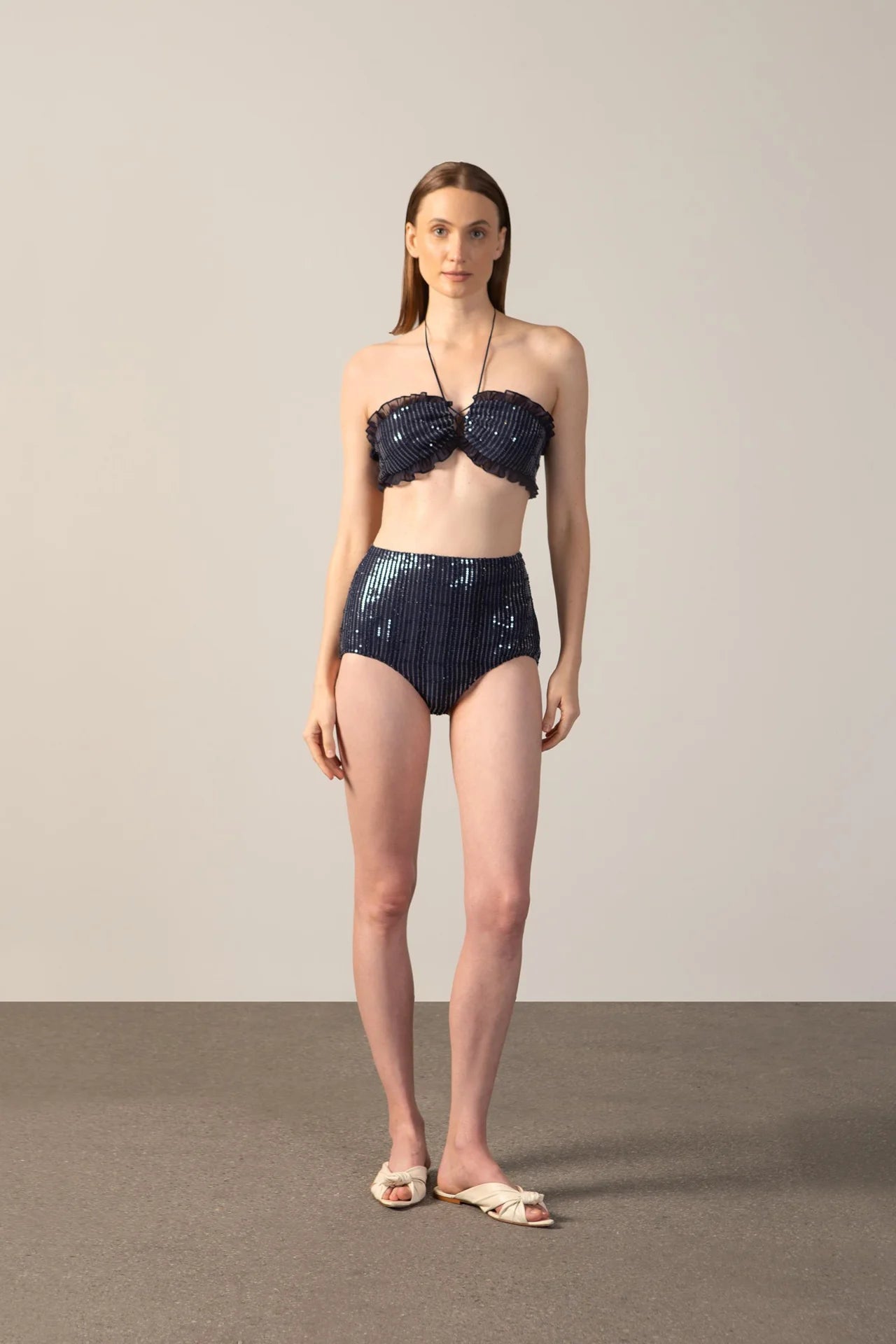 Model wearing the Sequins High-Waist Bikini navy color front from the HS25 with 100% polyester styled for a drinks at the boat look.