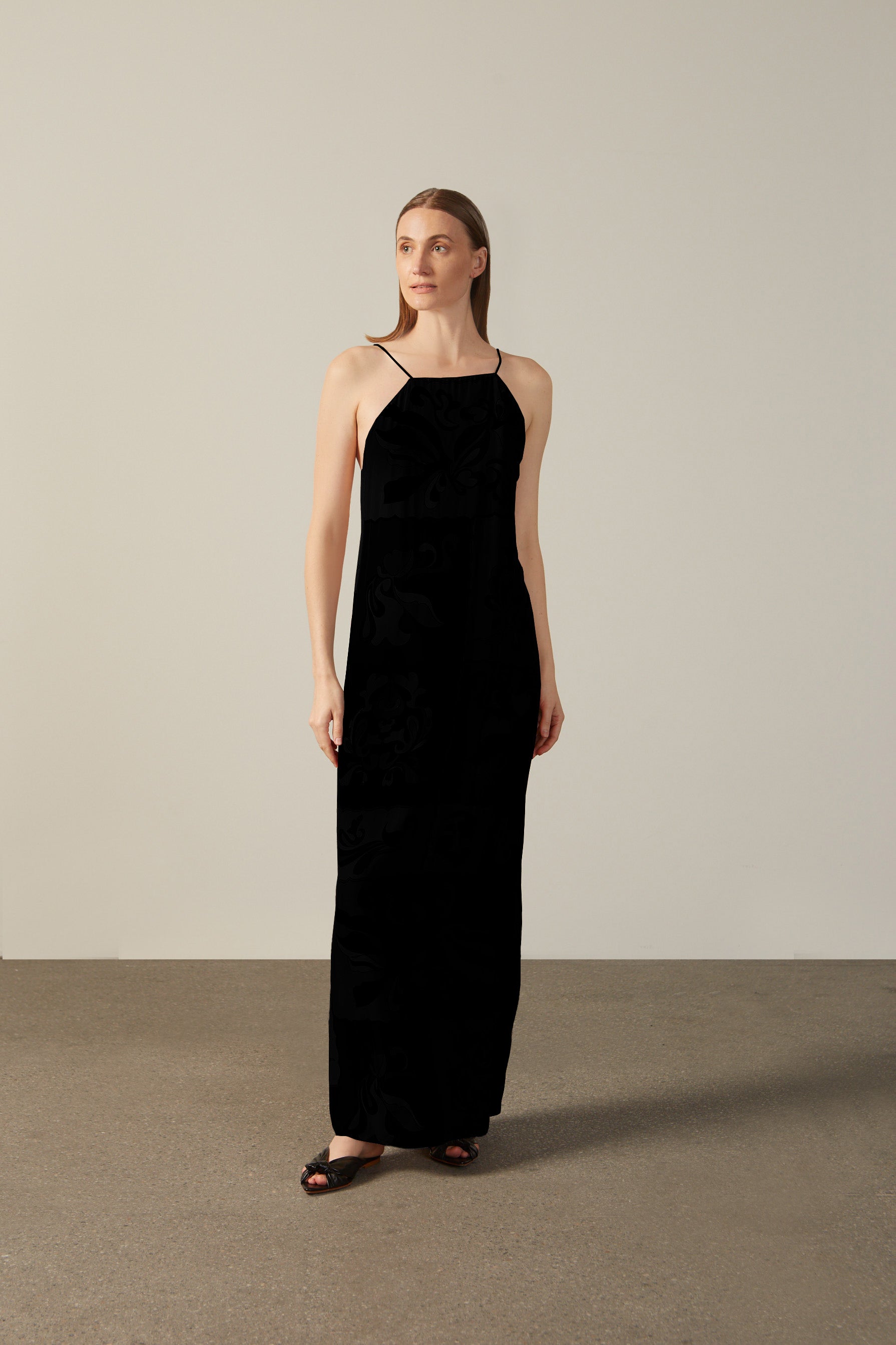 Model wearing the Solid Inamorata Bare-Back Long Dress Front showcasing its Black color on 100% Viscose fabric, styled for an evening look.