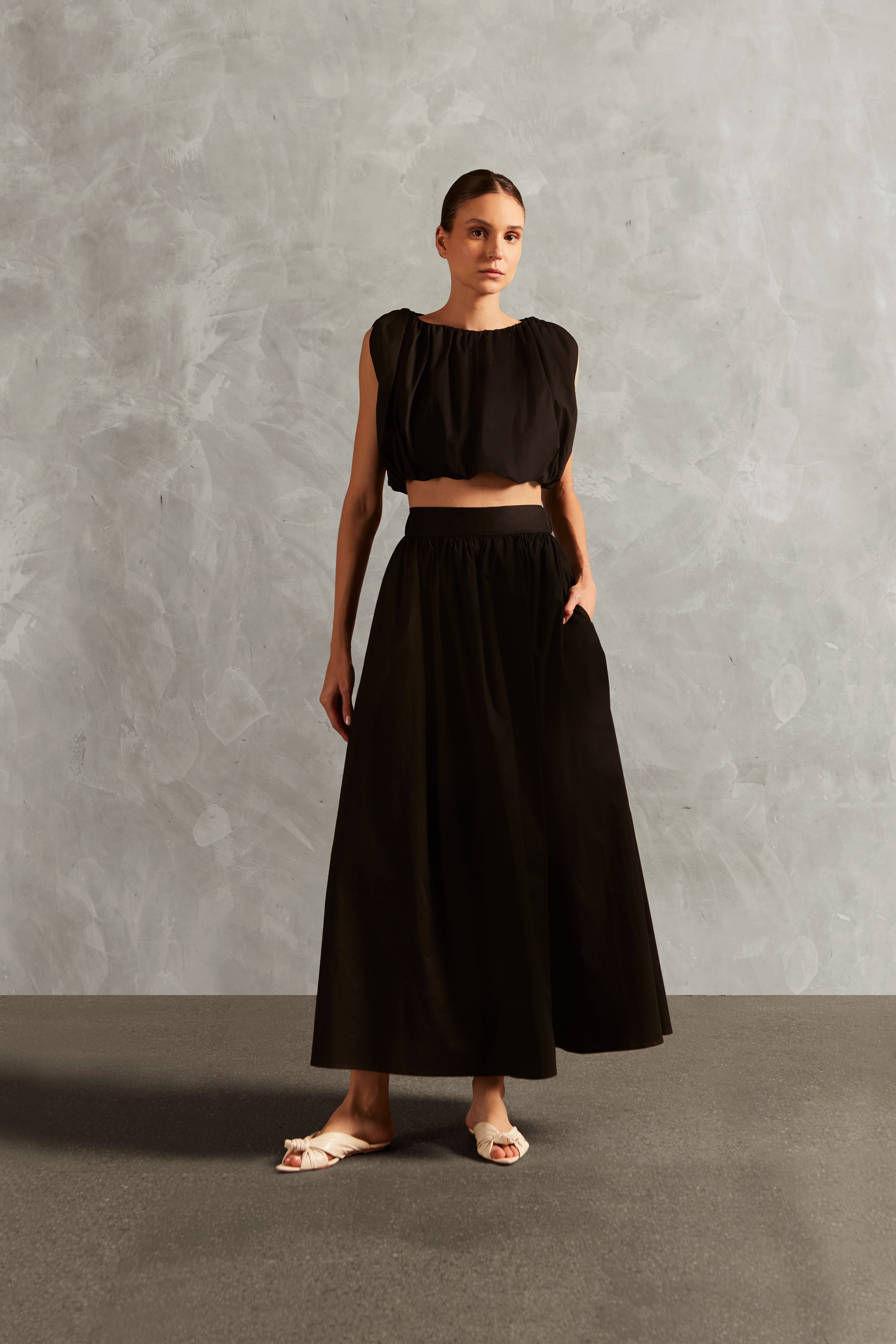 Model wearing the Solid Inamorata Cropped Blouse Front showcasing its Black color on 98% Cotton 2% Elastane fabric, styled for an afternoon look.
