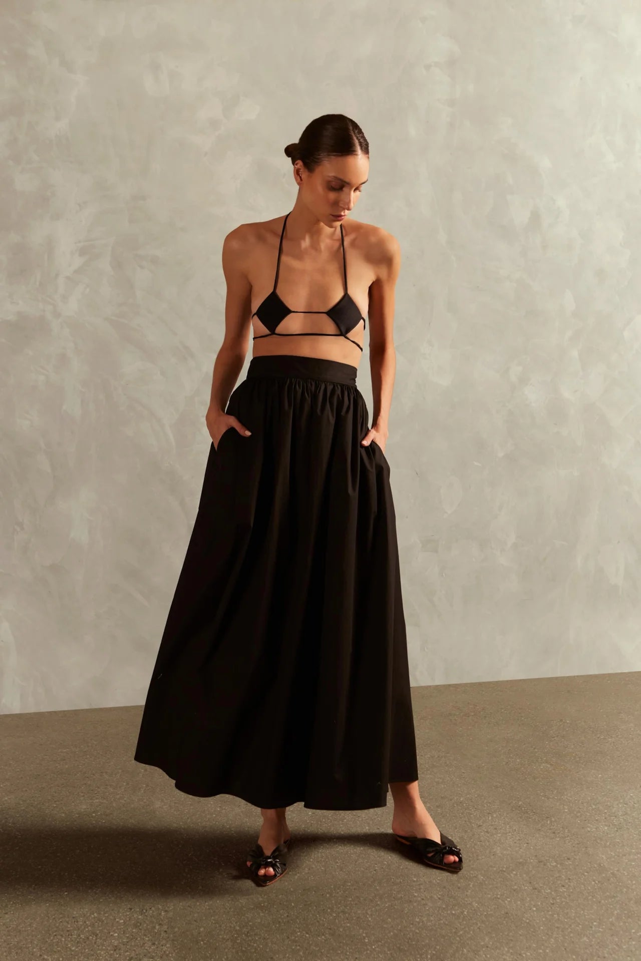 Model wearing the Solid Inamorata Long Skirt front color black, styled for a resort look.