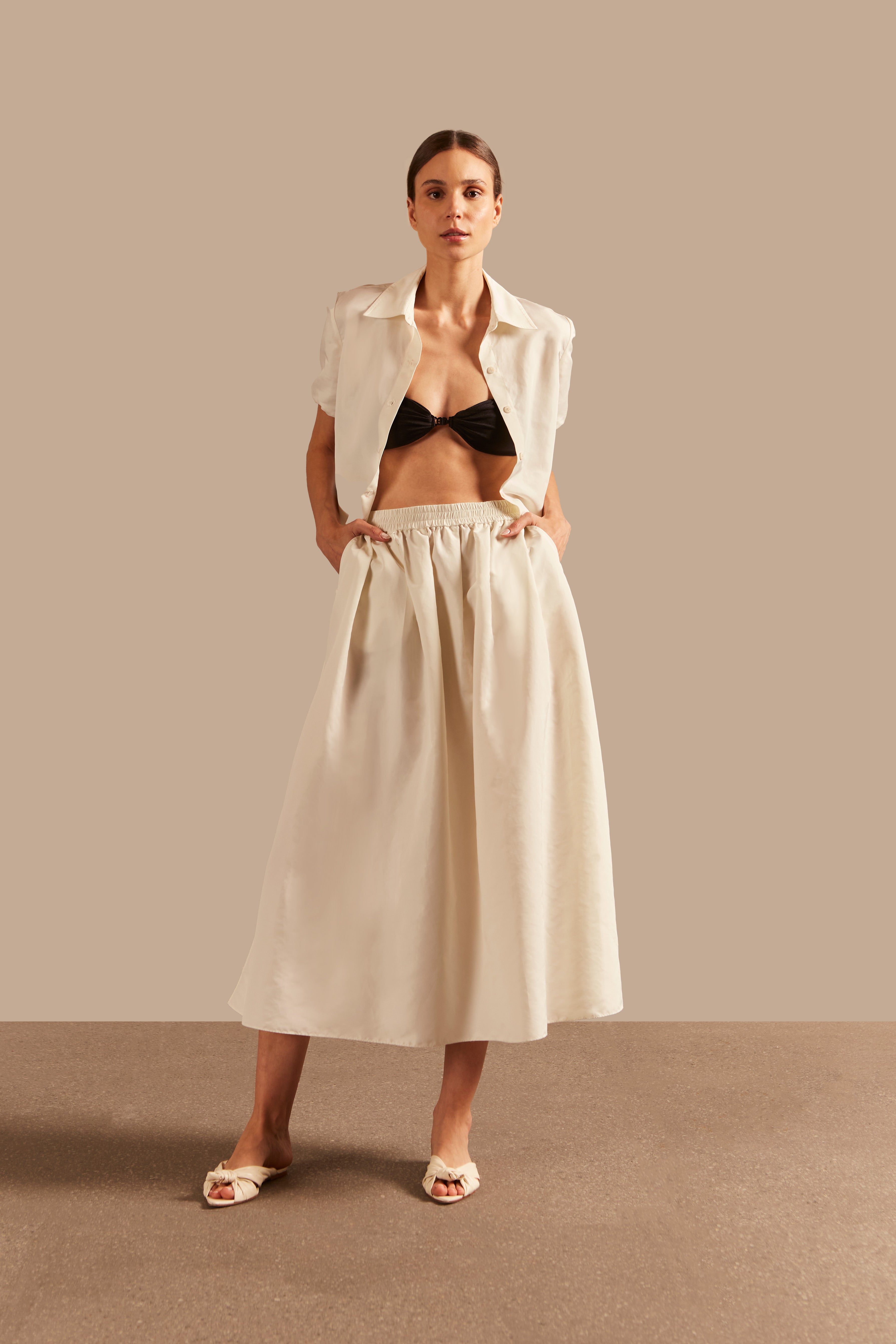 Model wearing the Solid Inamorata Long Skirt front color off white, styled for a resort look.