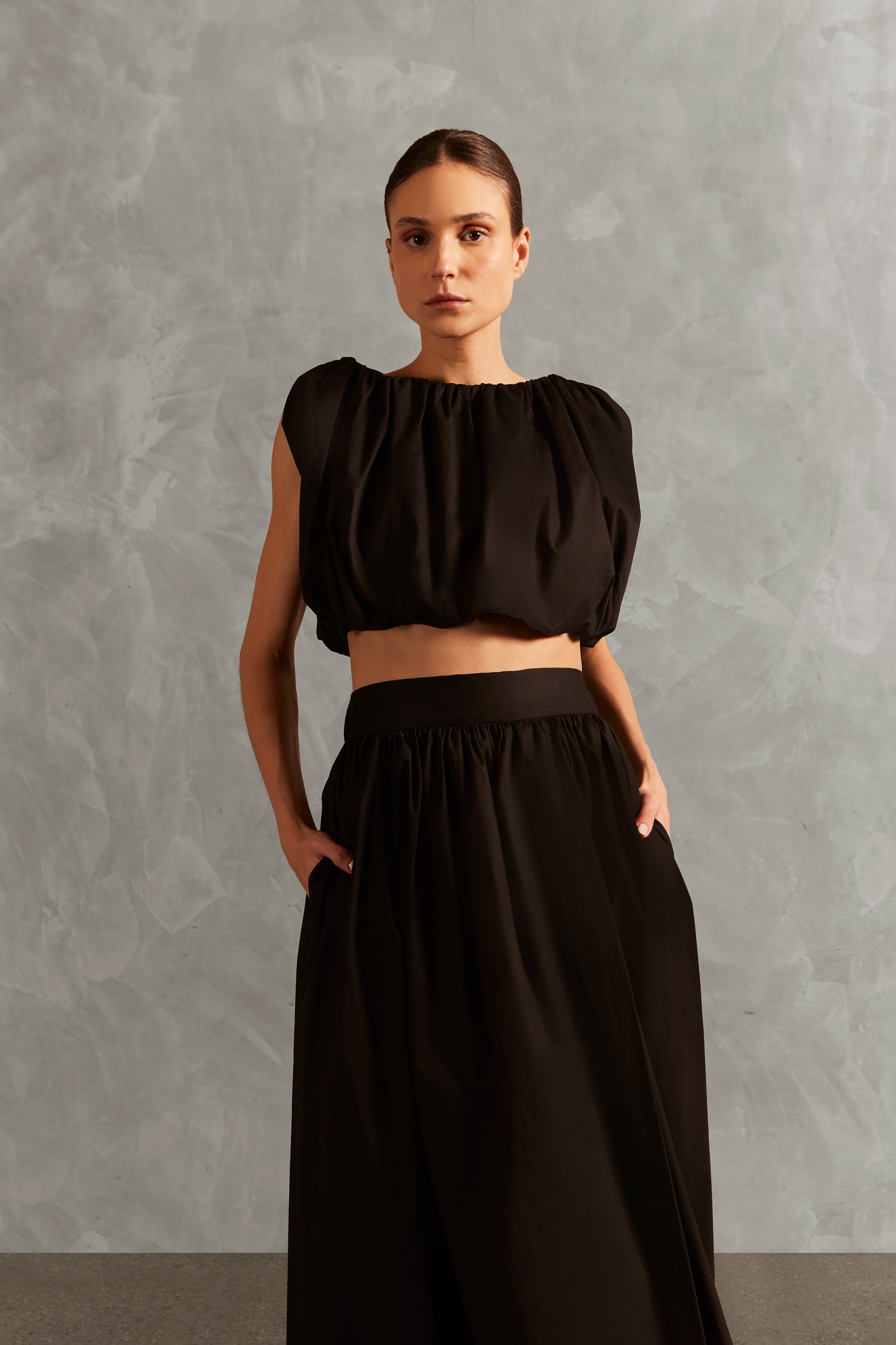 Model wearing the Solid Inamorata Side-Slit Long Skirt Detail showcasing its Black color on 98% Cotton 2% Elastane fabric, styled for an afternoon look.
