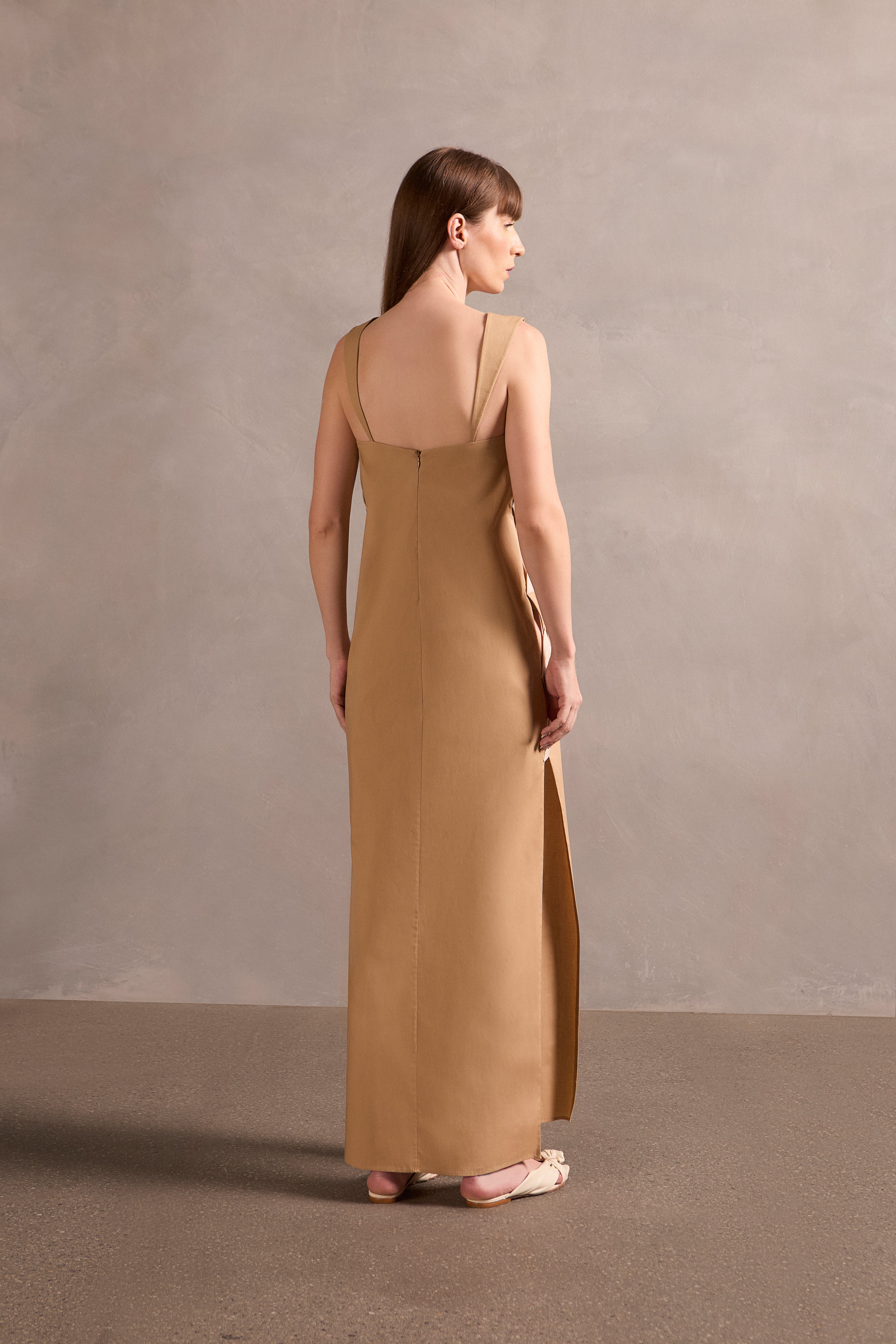 Model wearing the Solid Cut-Out Long Dress Back showcasing its Beige print on 98% Cotton 2% Spandex fabric, styled for an afternoon look.